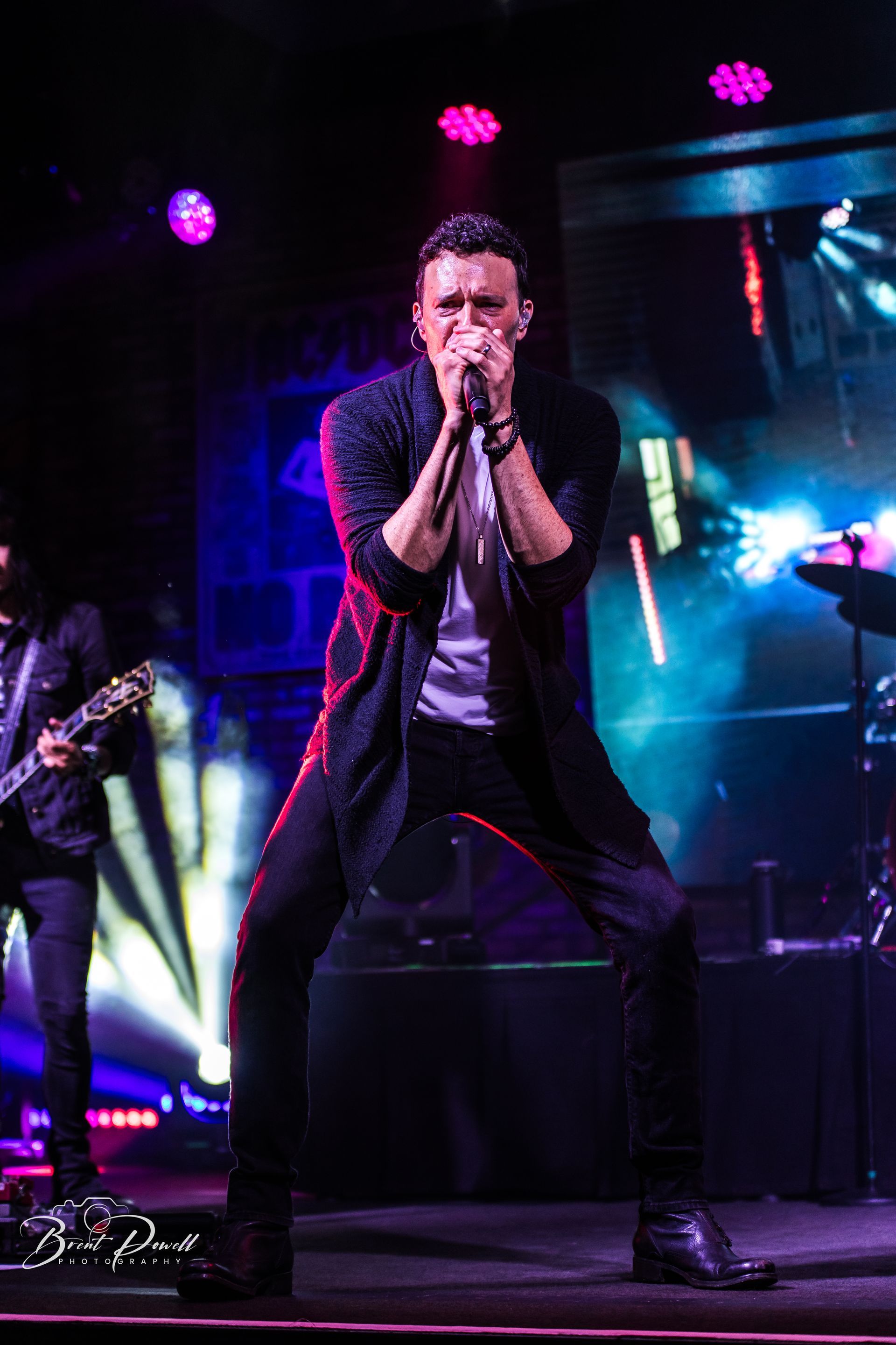 A man is singing into a microphone on a stage.