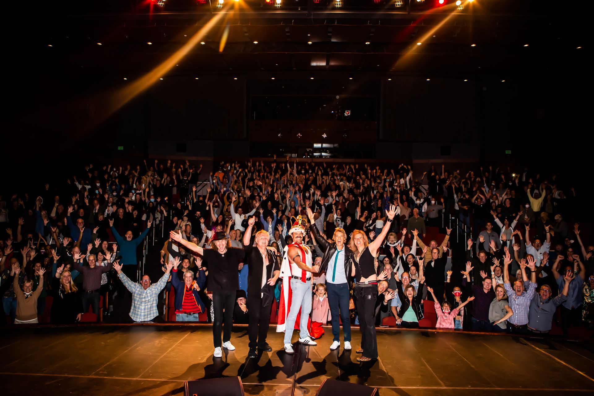 A group of people are standing on a stage in front of a crowd.