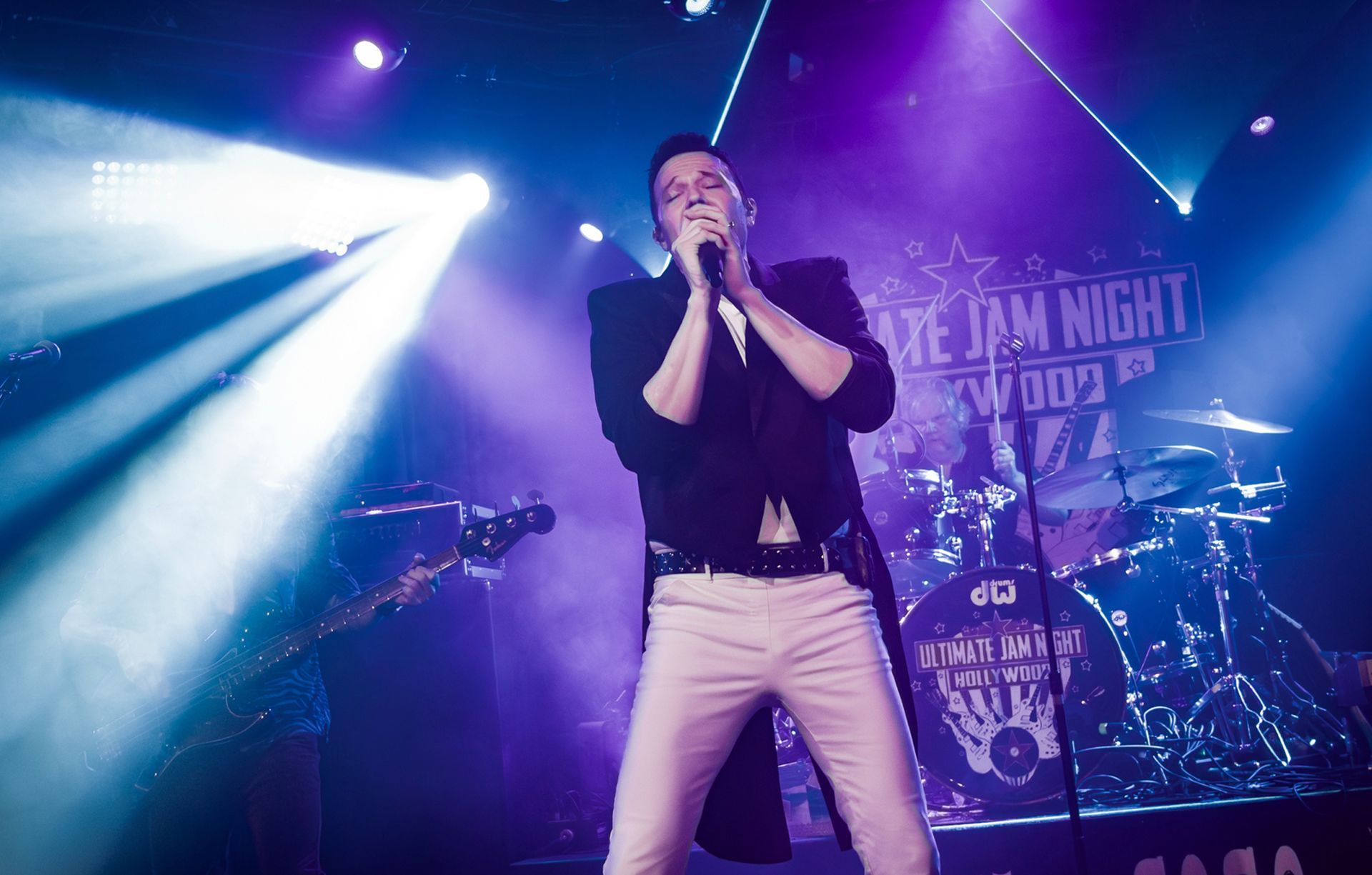 A man is singing into a microphone on a stage.
