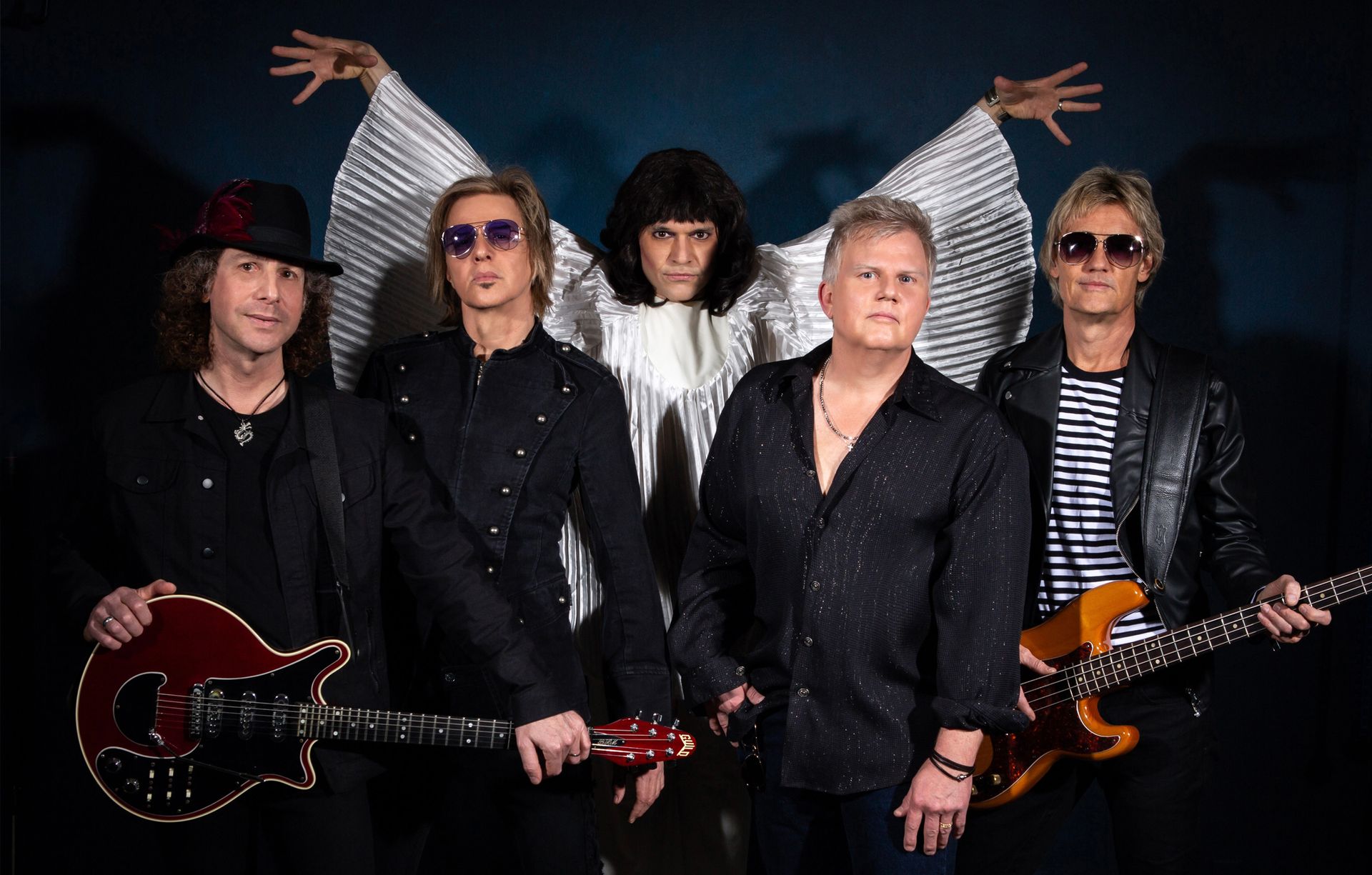 A group of men standing next to each other holding guitars.