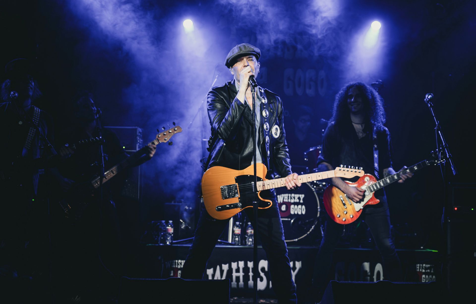 A black and white photo of a band performing on stage