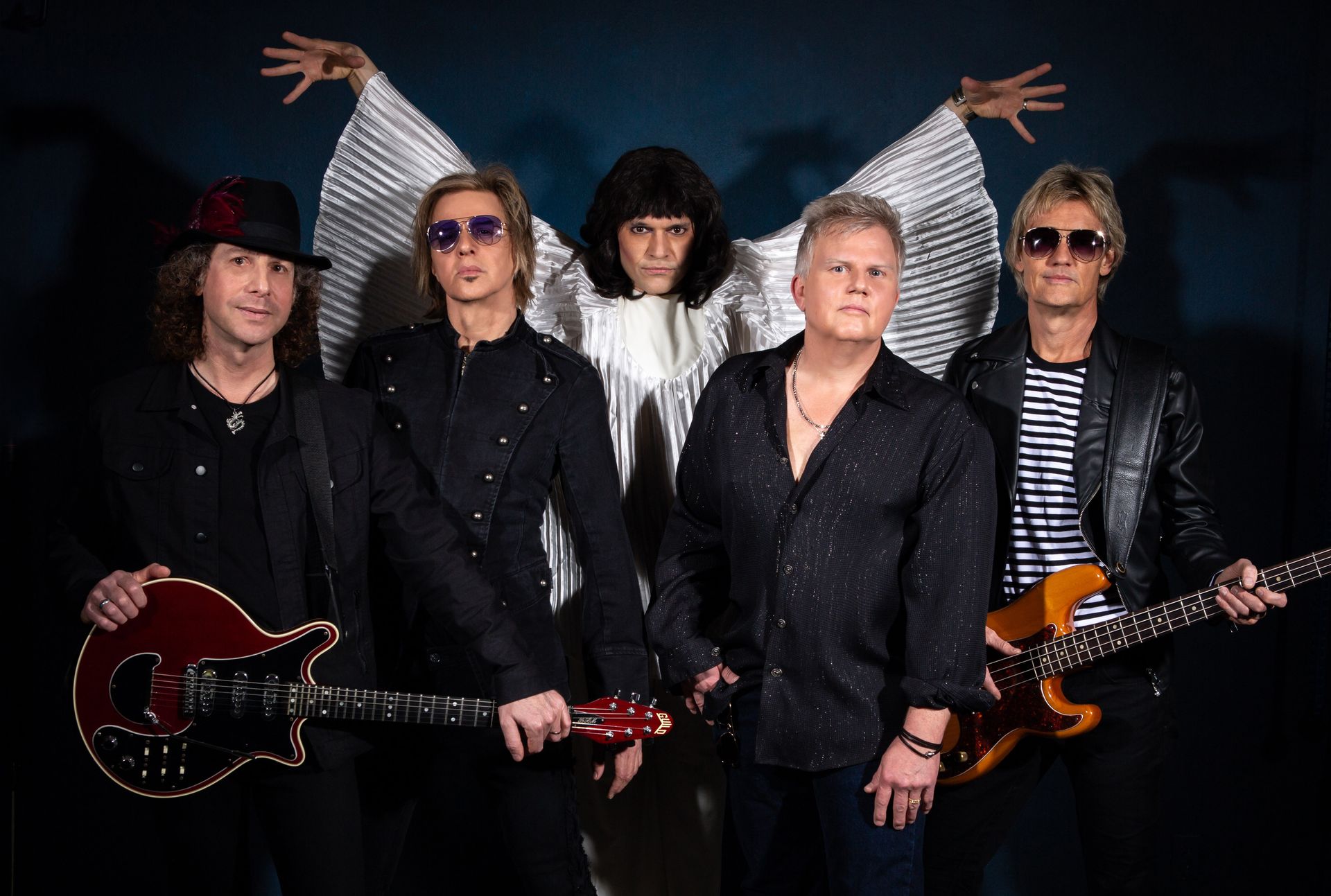 A group of men standing next to each other holding guitars.