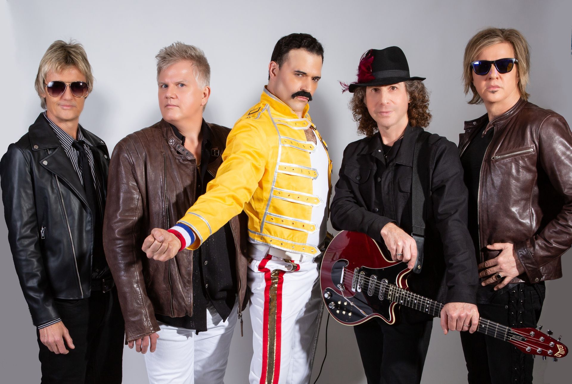 A group of men standing next to each other holding guitars.