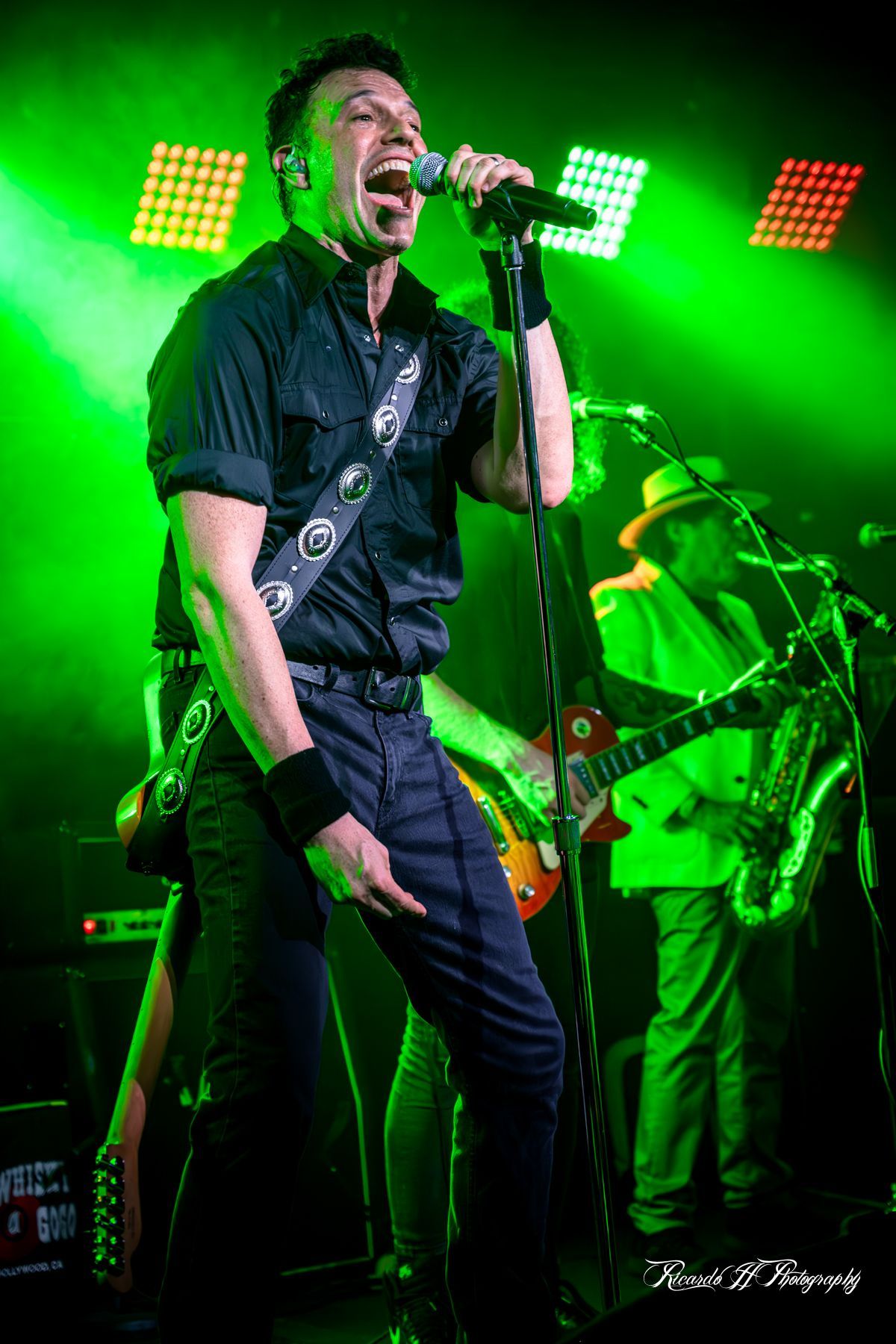 A man is singing into a microphone on a stage.