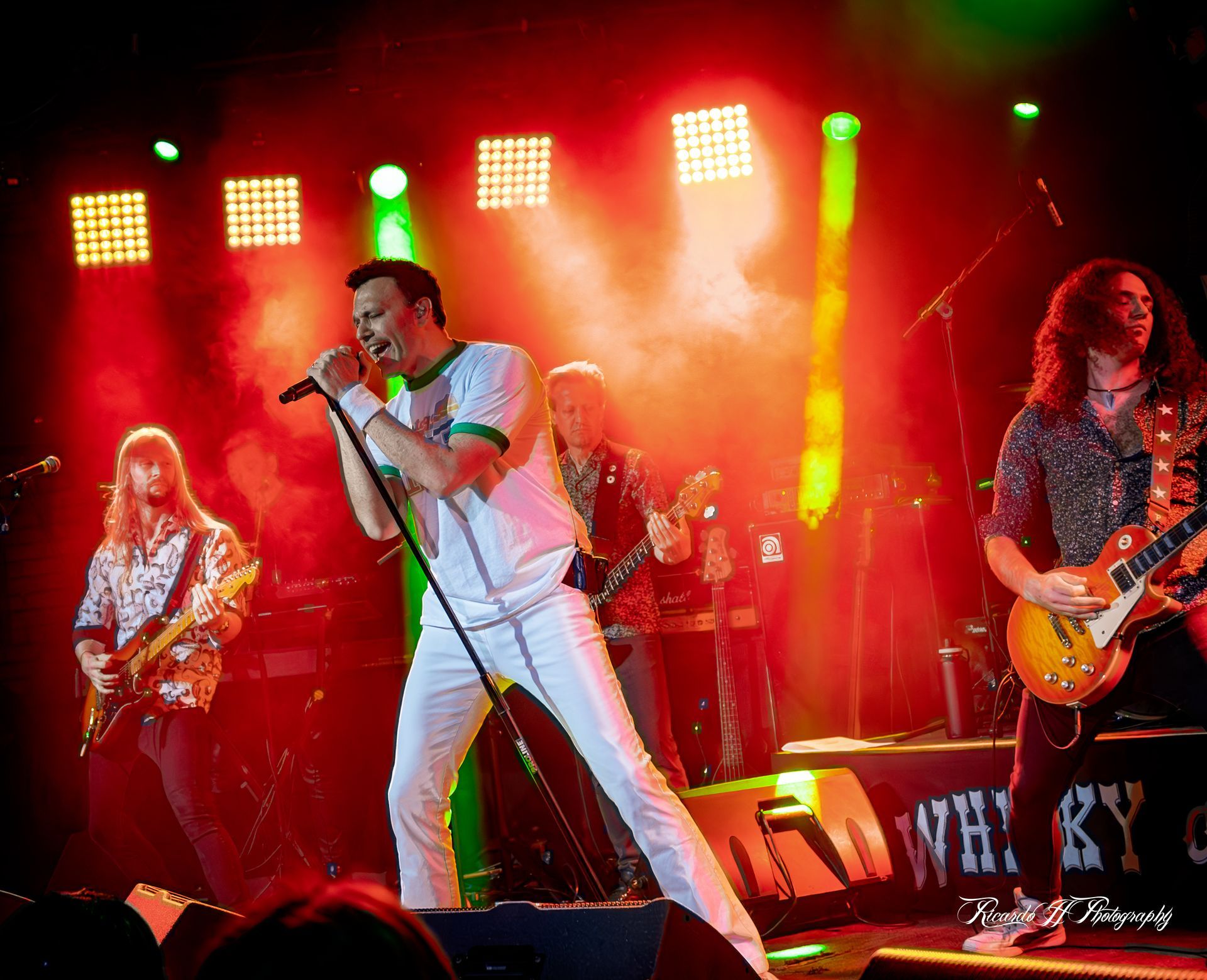 A group of men are playing guitars and singing on a stage.