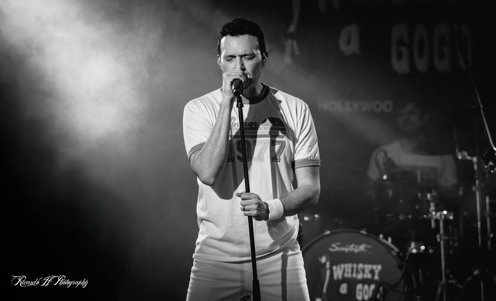 A man is singing into a microphone on a stage.