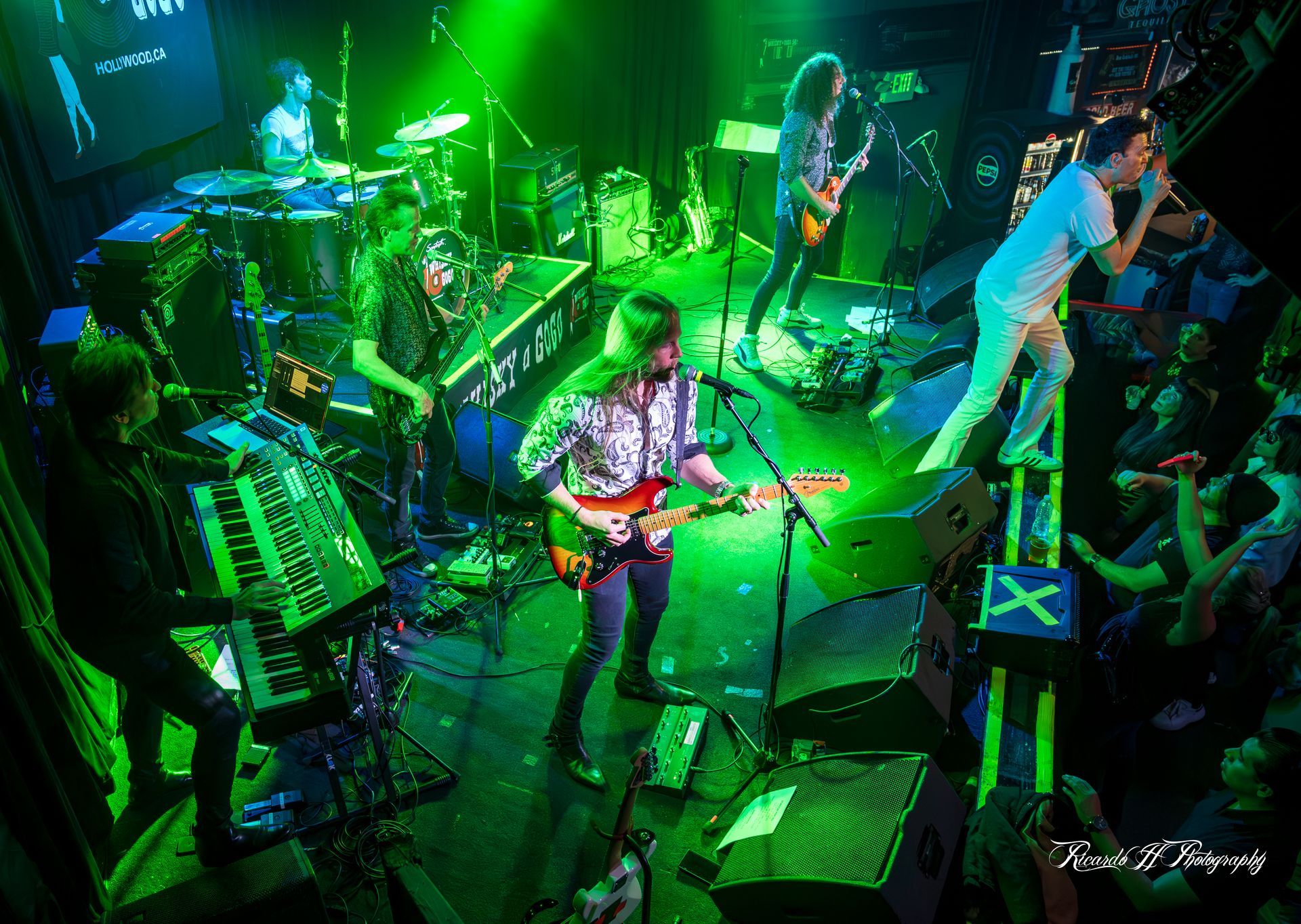 A group of people are playing instruments on a stage in front of a crowd.