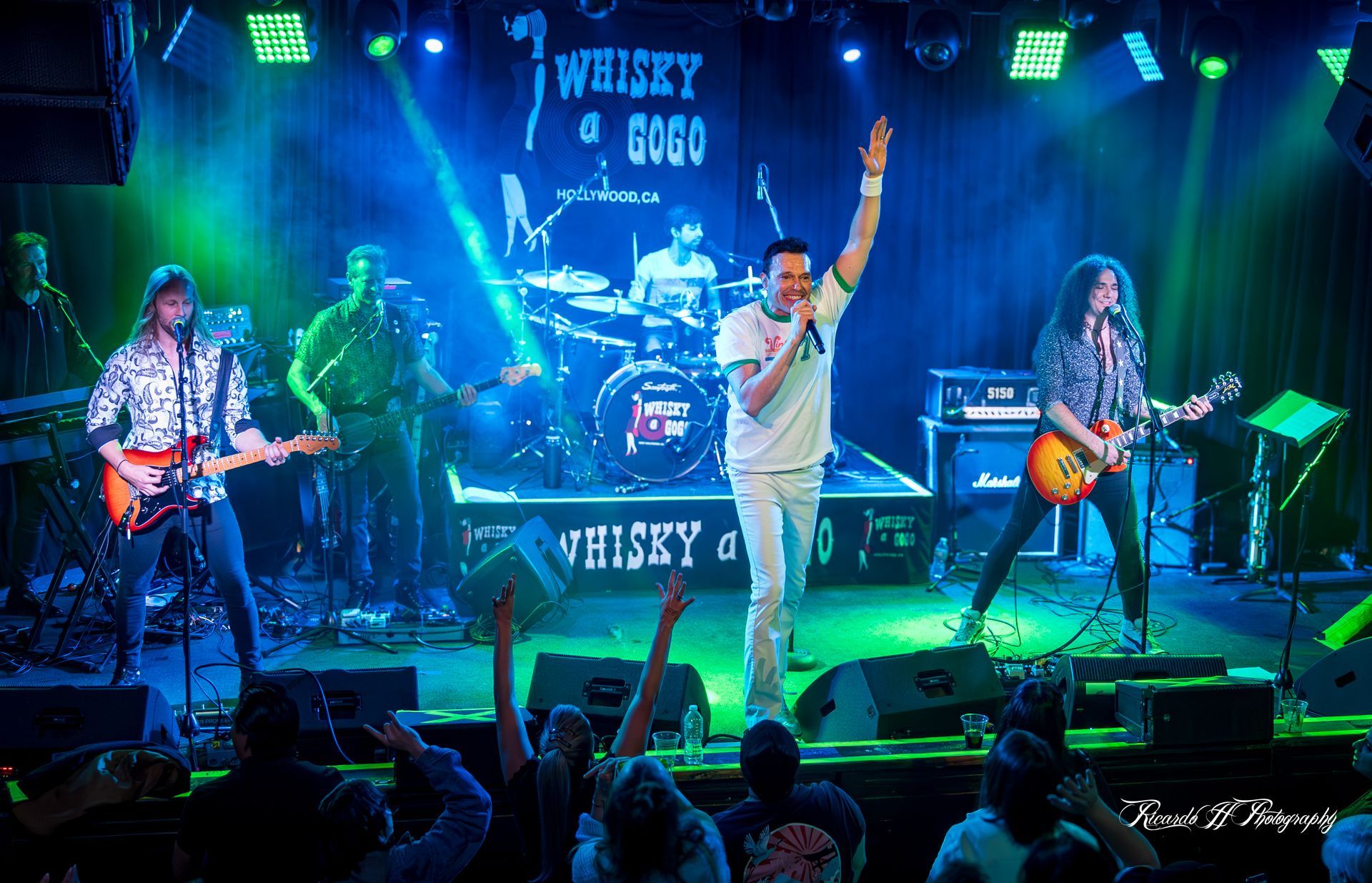 A group of people on stage with a sign that says whisky on it