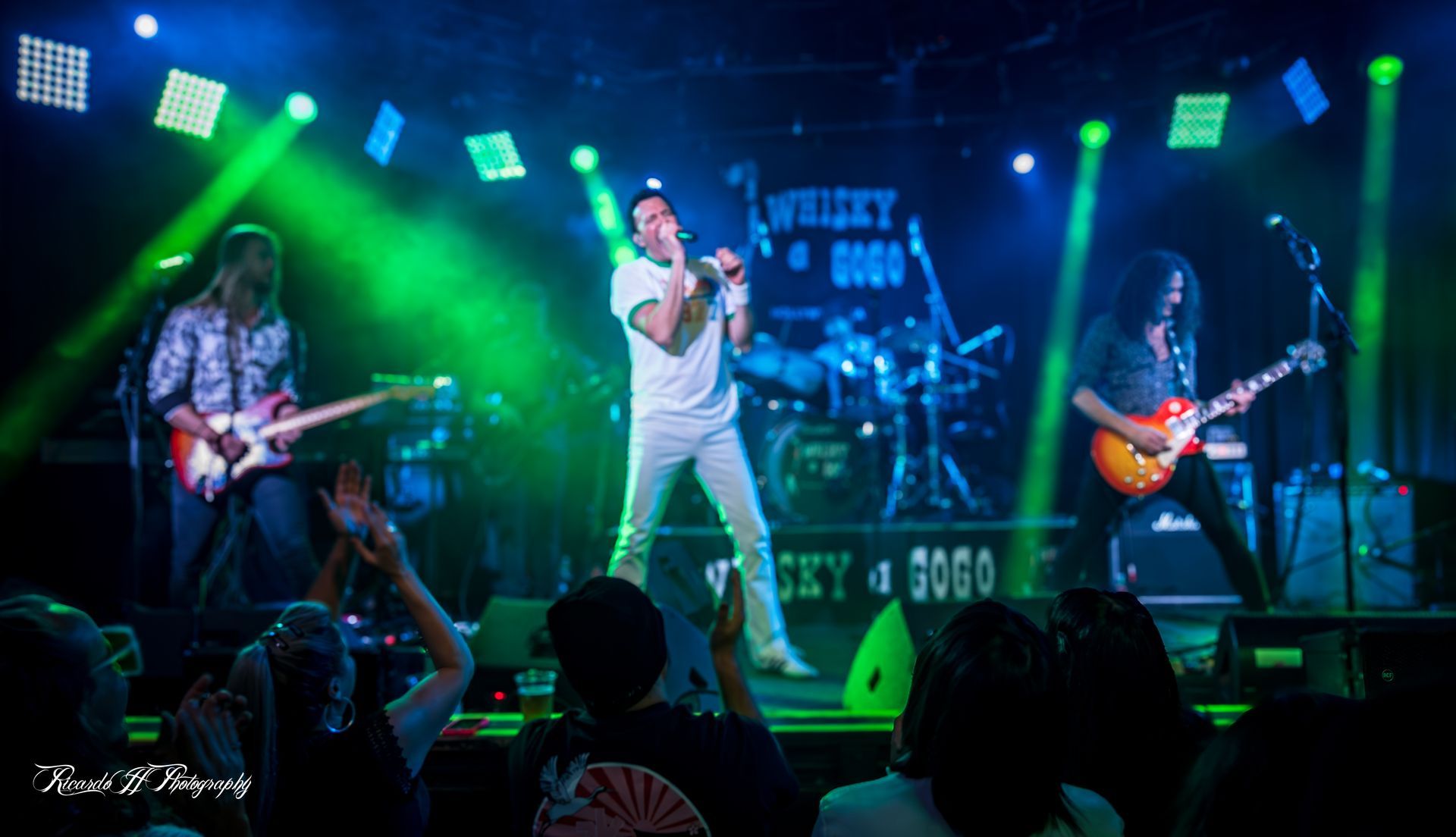 A group of people are playing instruments on a stage in front of a crowd.