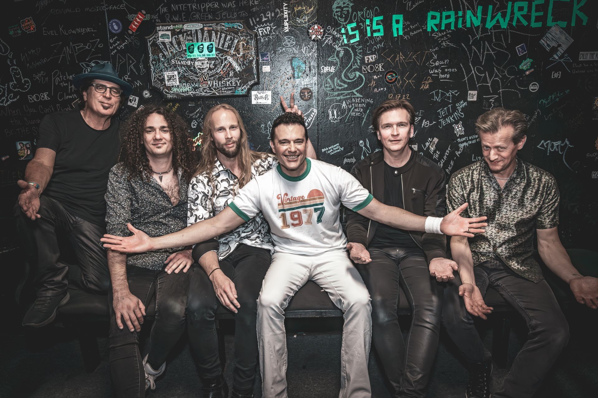A group of men are posing for a picture in a dark room.