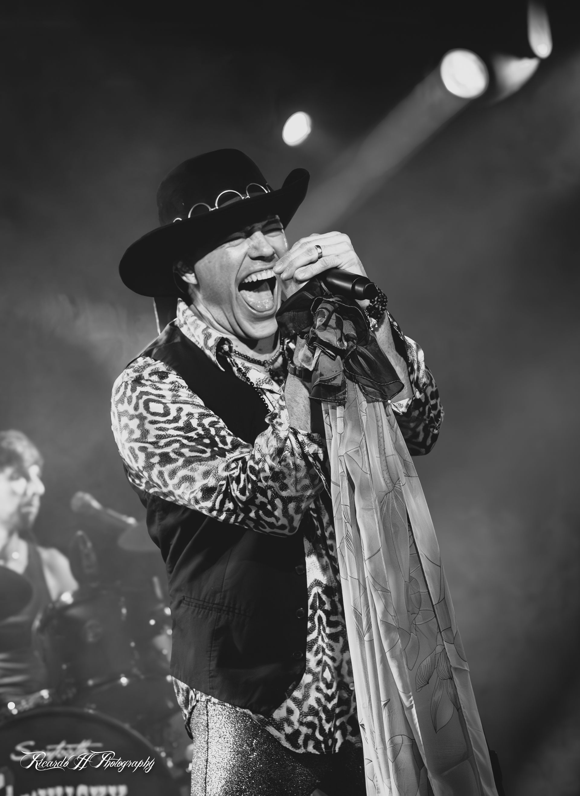 A black and white photo of a man singing into a microphone
