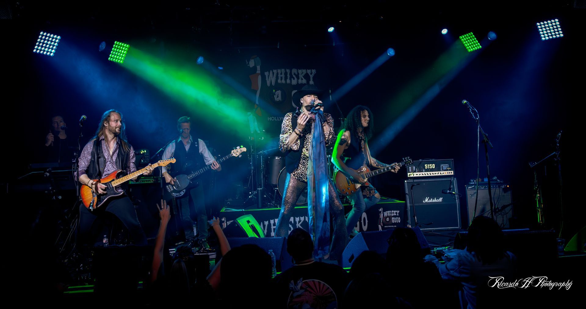 A group of people are playing instruments on a stage in front of a crowd.