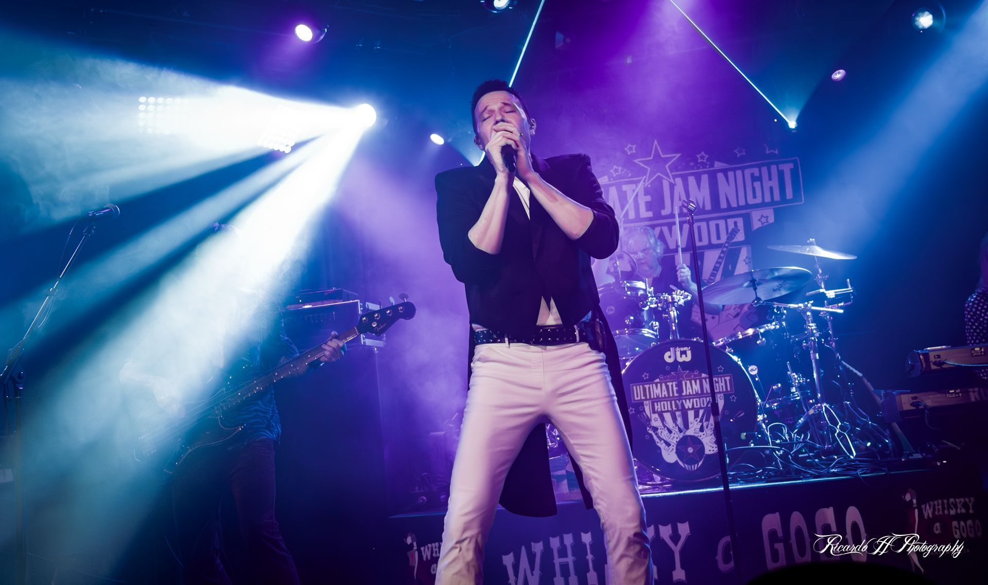 A man is singing into a microphone on a stage.