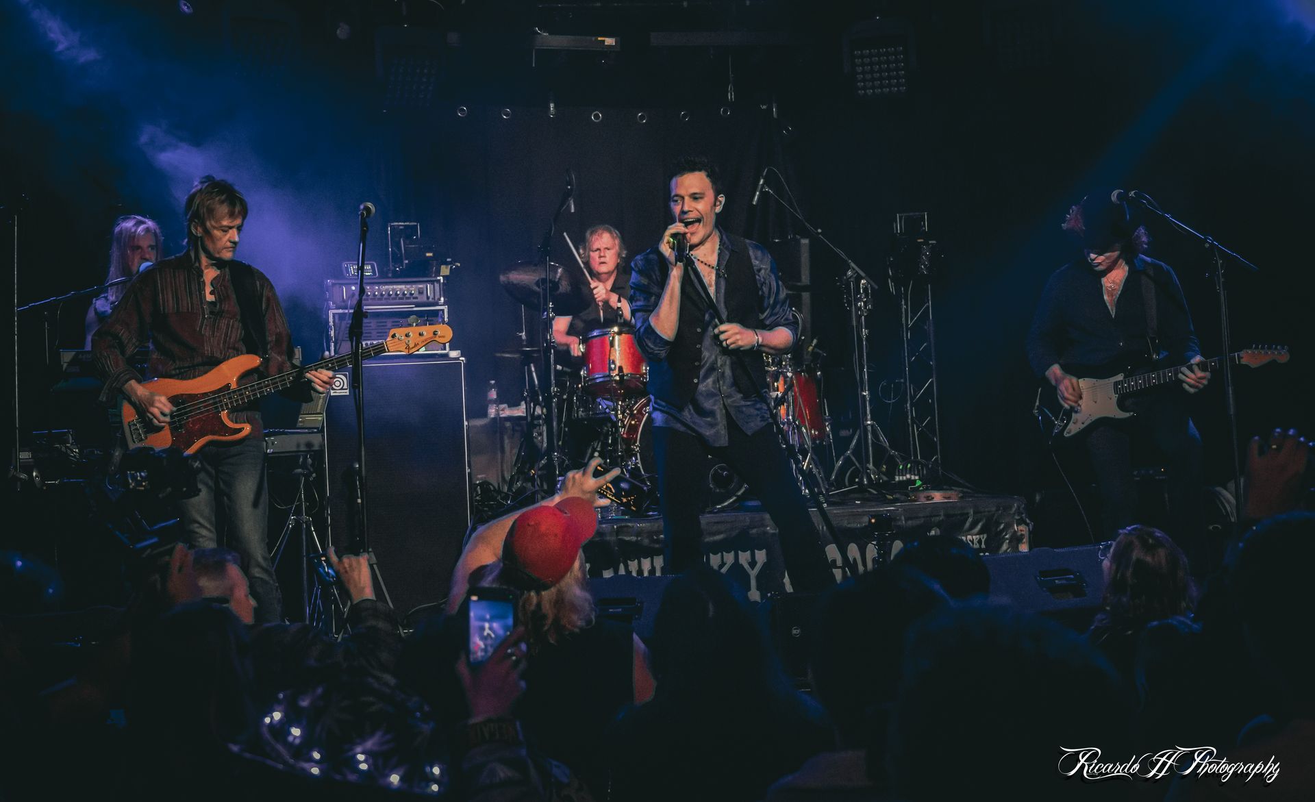 A group of people are playing instruments on a stage in front of a crowd.