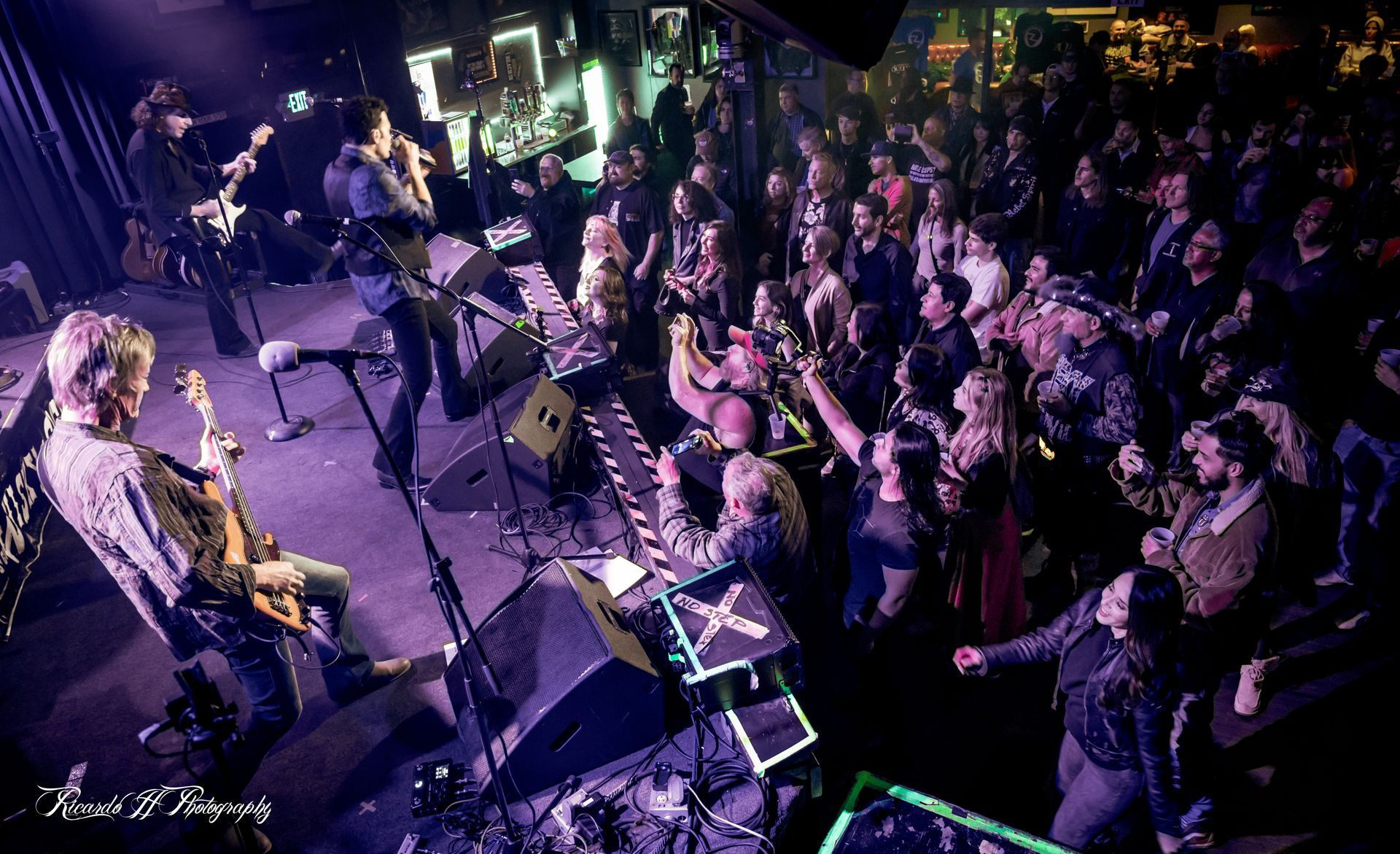 A group of people are playing instruments on a stage in front of a crowd.