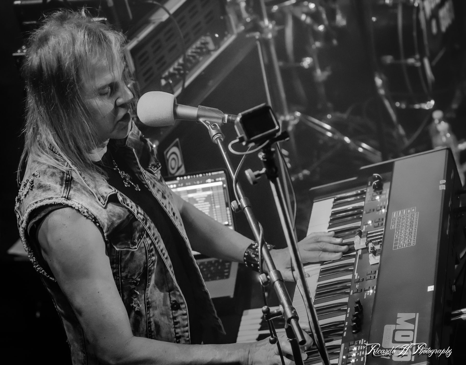 A man is playing a keyboard and singing into a microphone.