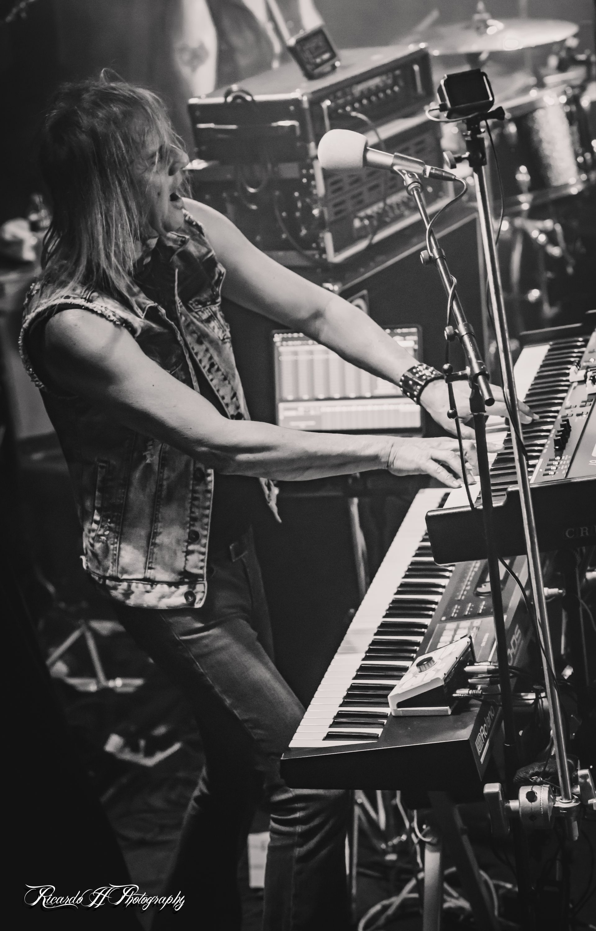 A man is playing a keyboard in a black and white photo.