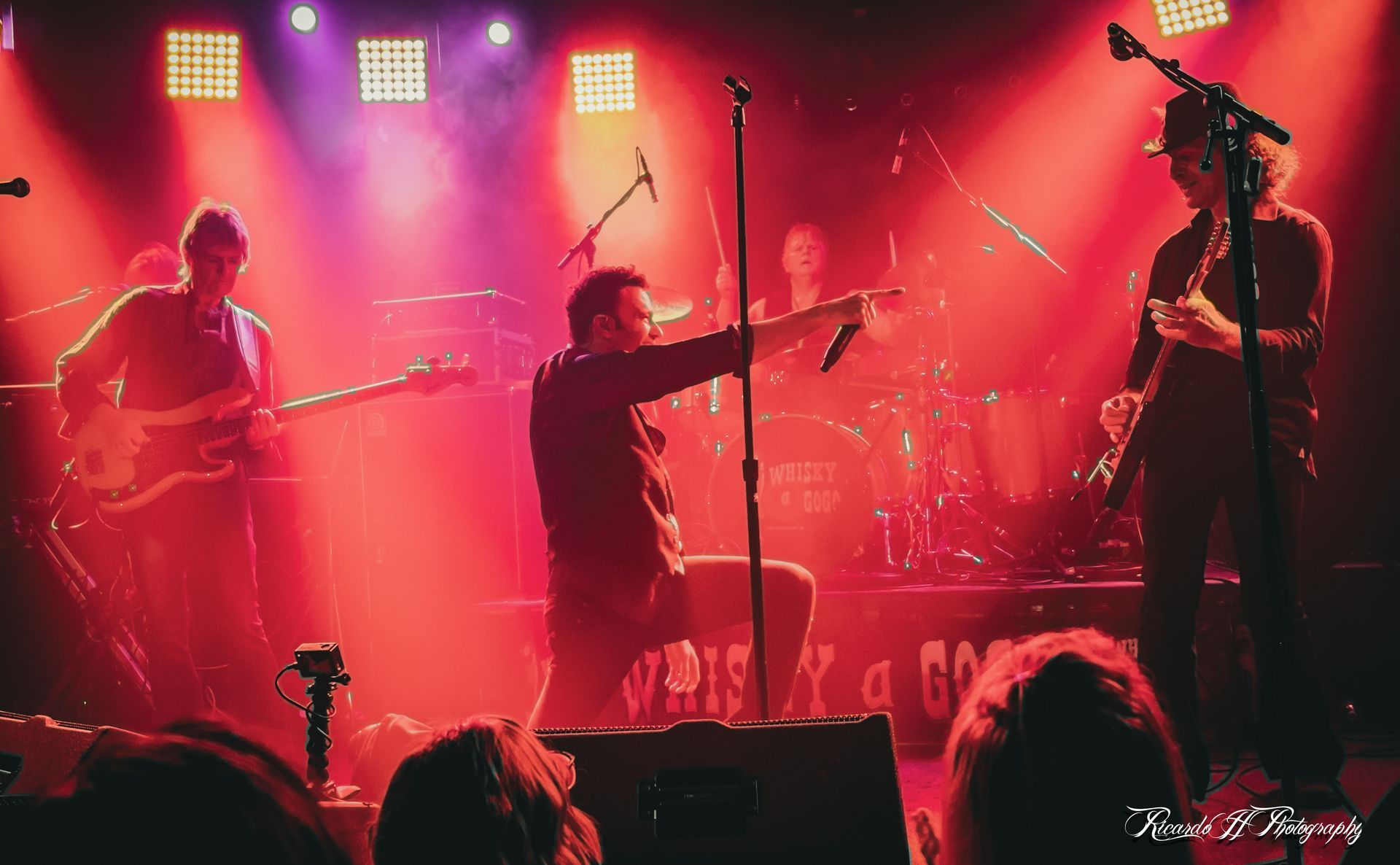 A group of people are playing instruments on a stage in front of a crowd.