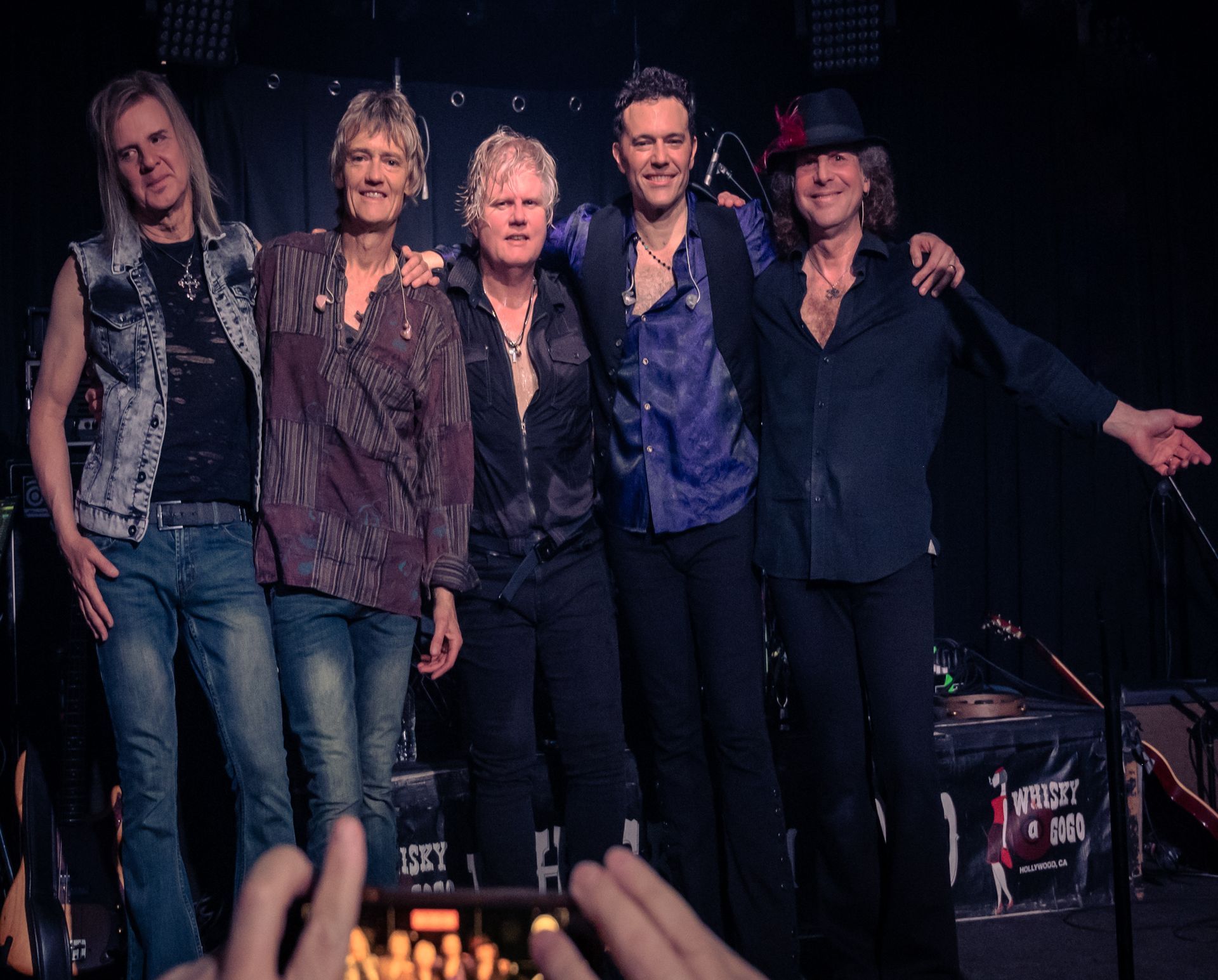 A group of men are posing for a picture in a dark room
