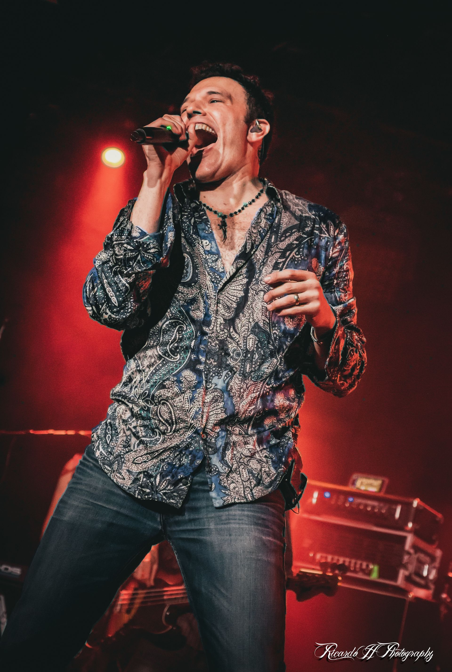 A man is singing into a microphone on a stage.