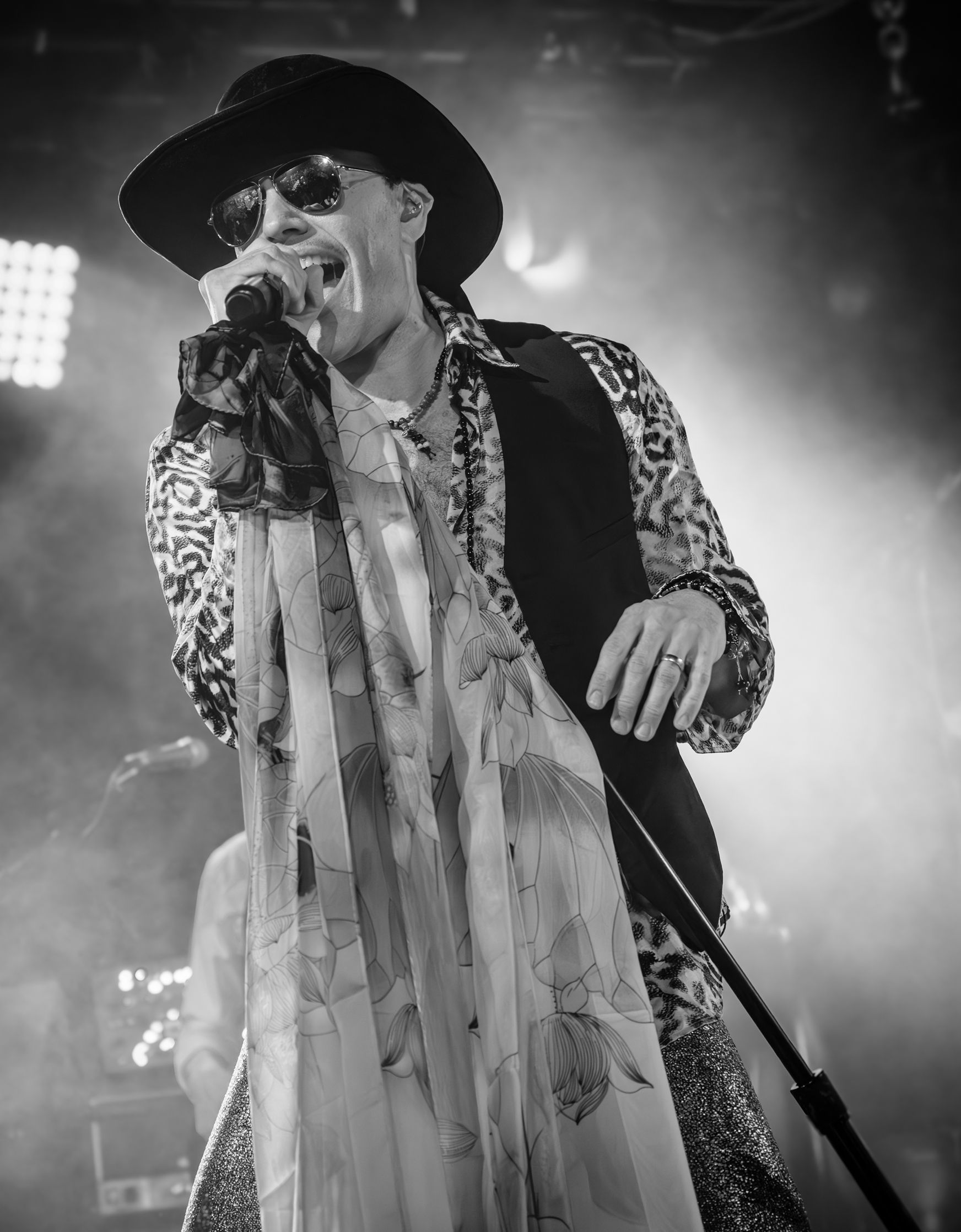 A black and white photo of a man singing into a microphone.