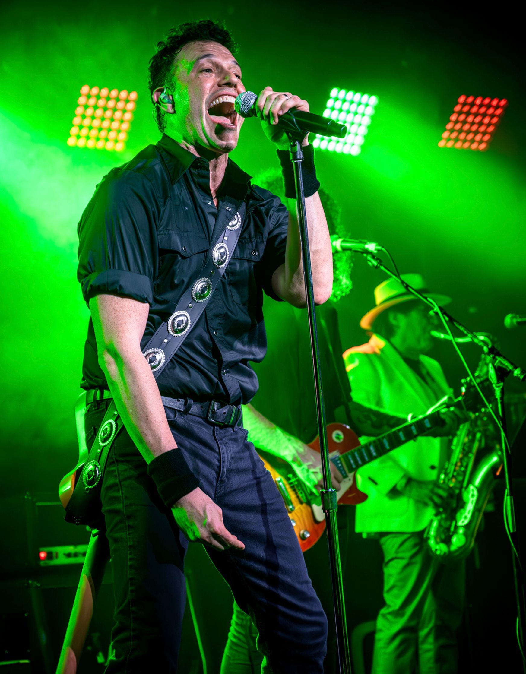 A man playing a guitar in front of a sign that says jack daniels