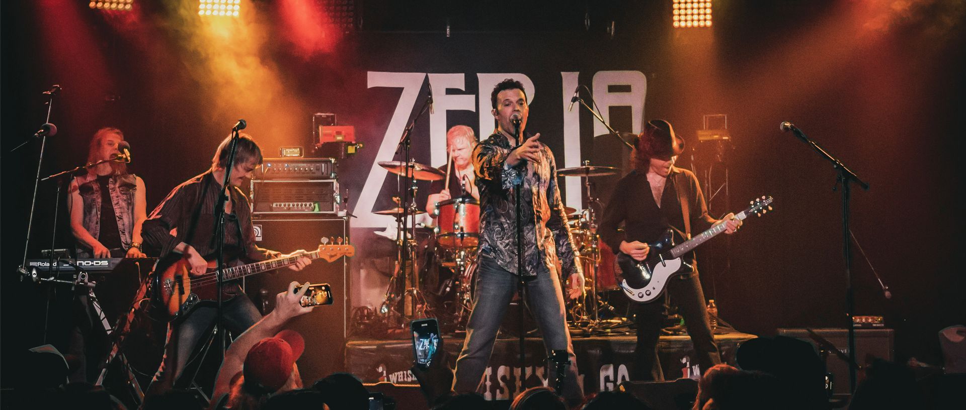 A group of people are playing instruments on a stage in front of a crowd.