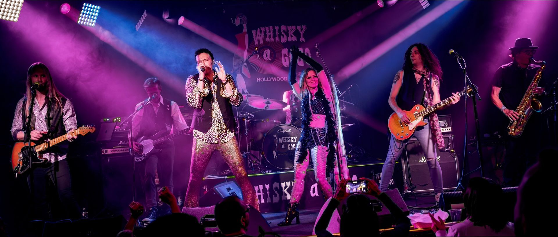 A group of people are playing instruments on a stage in front of a crowd.