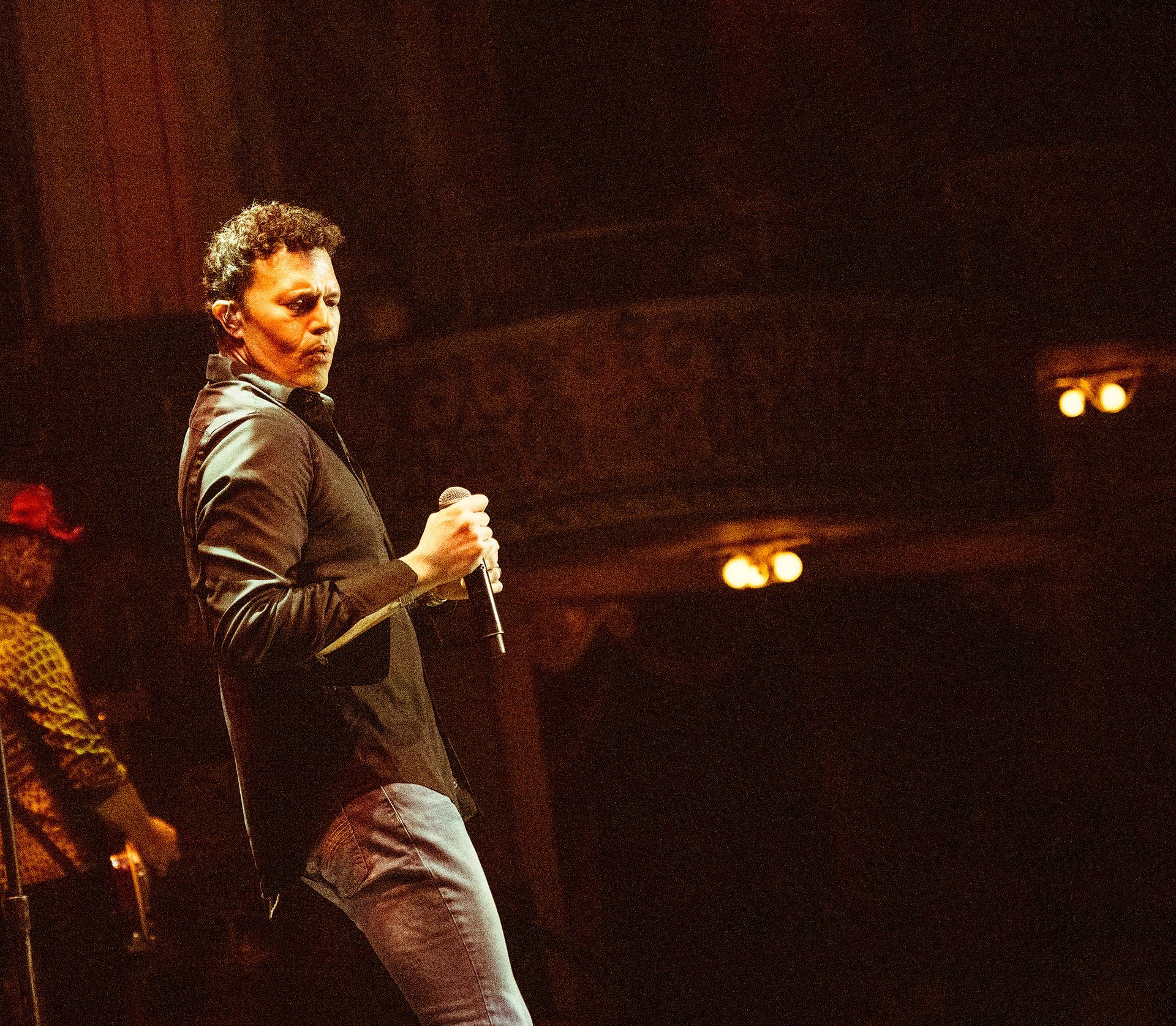A man singing into a microphone on a stage