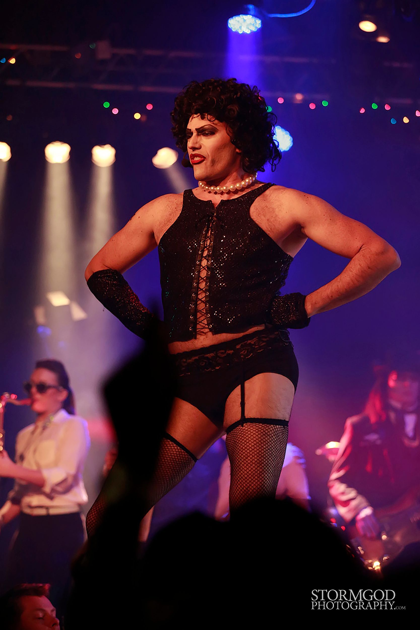 A drag queen is performing on stage in front of a crowd