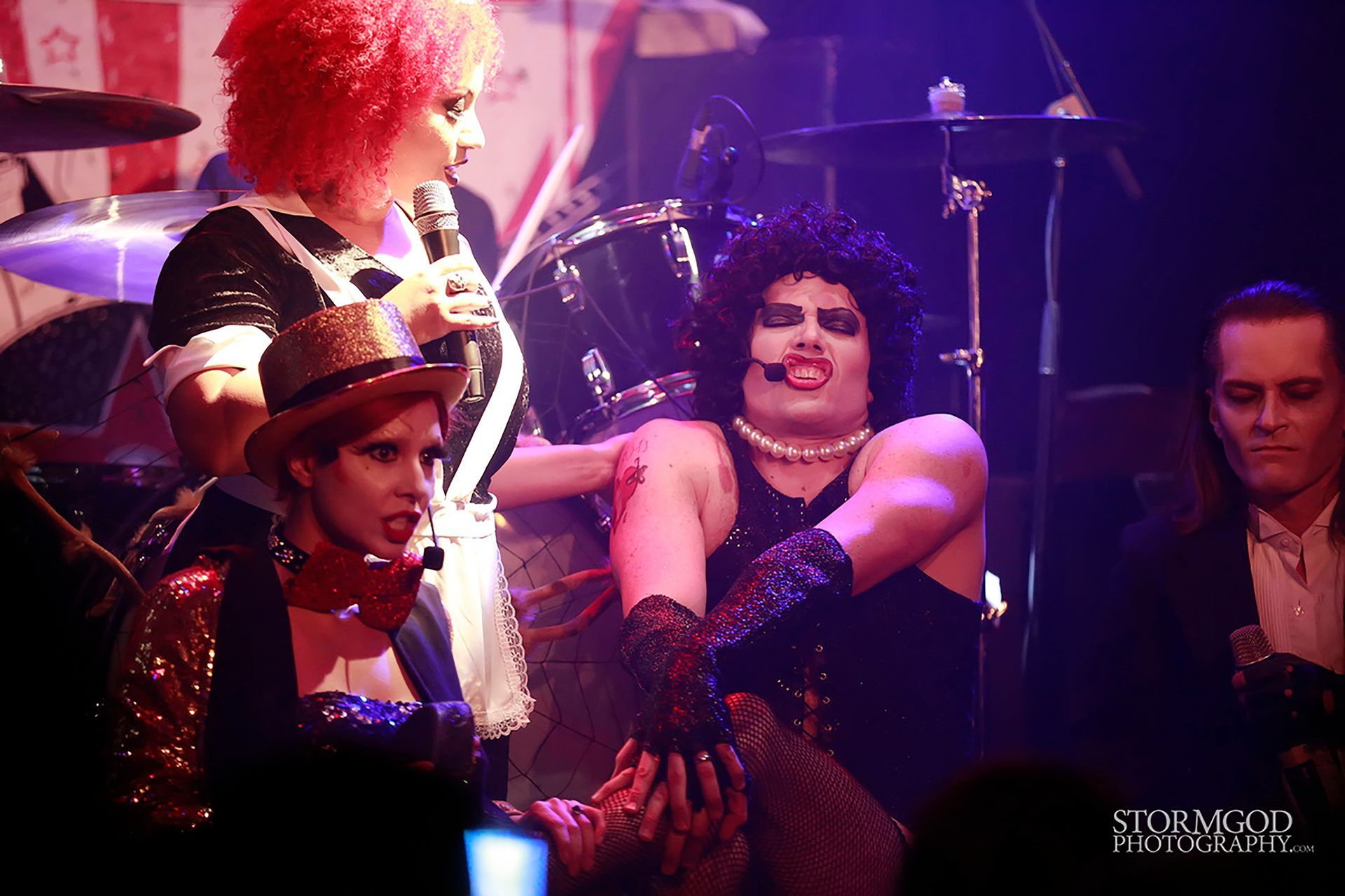 A group of people dressed in costumes are standing on a stage.