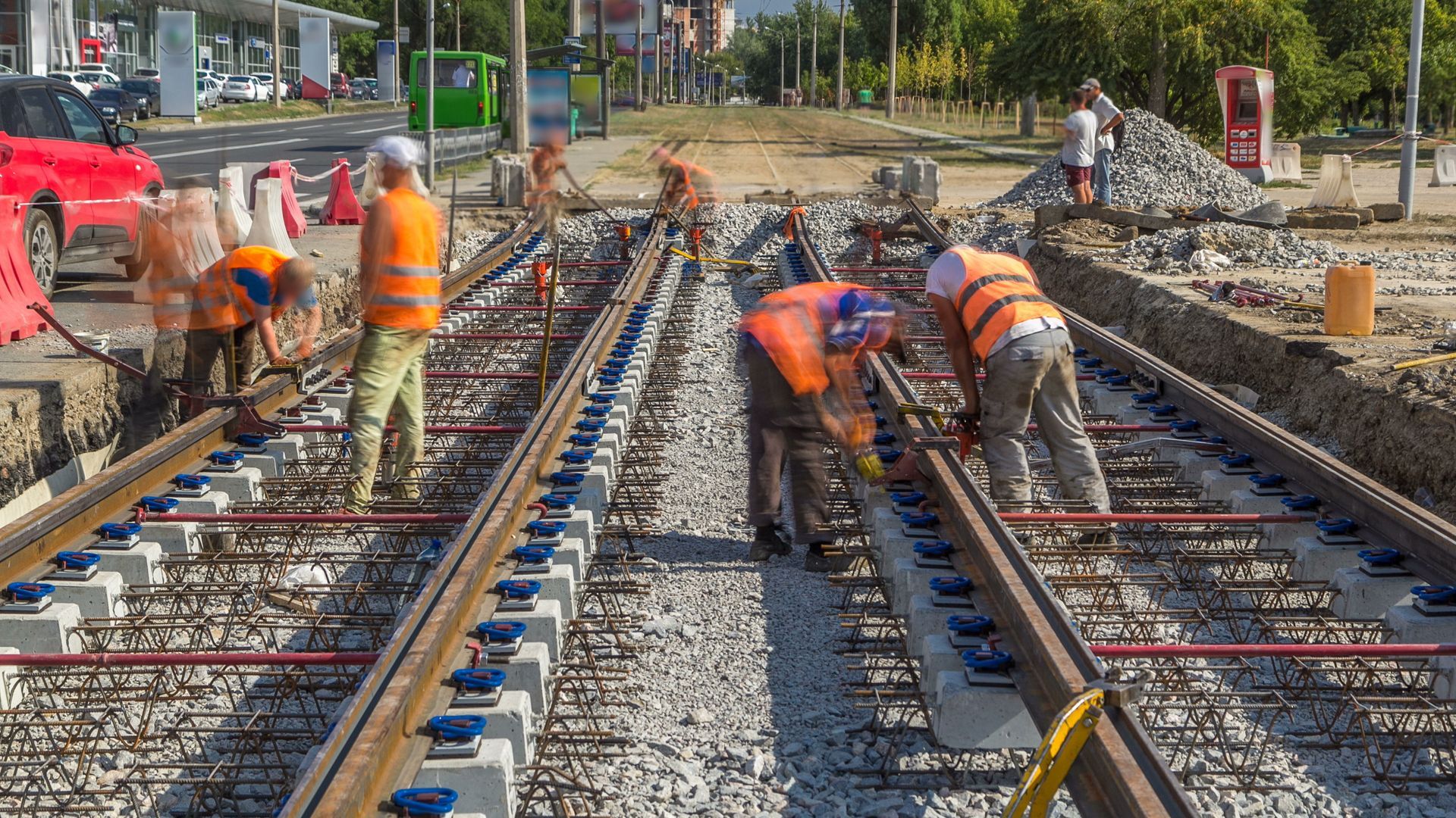 A group of construction workers are working on train tracks.