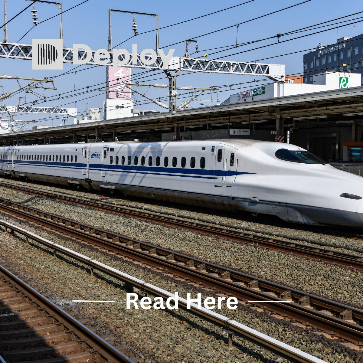A white bullet train on tracks at a station with a blue stripe and overhead wires.