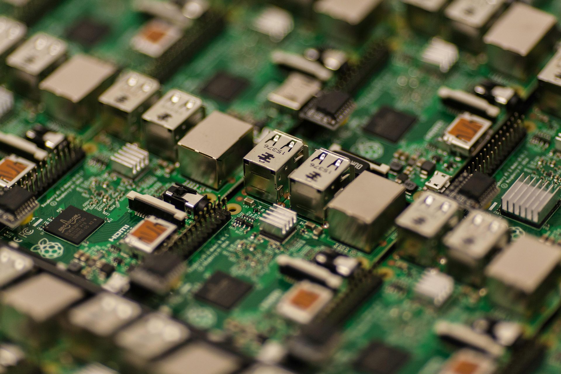 A close up of a stack of electronic components on a green motherboard.