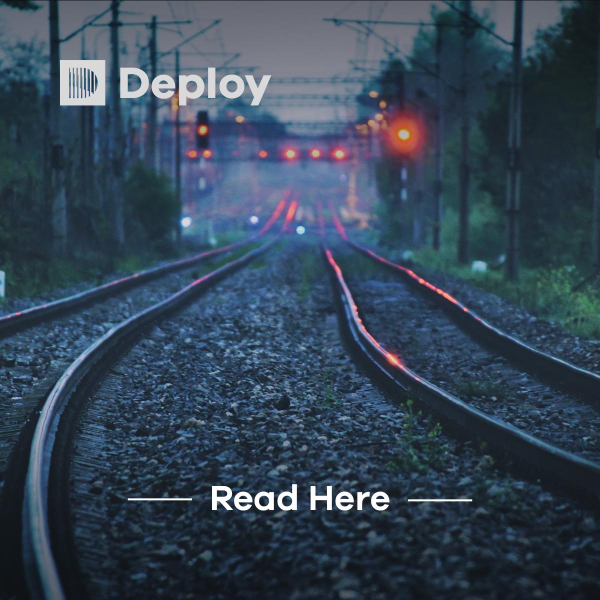 Railroad tracks receding into the distance, lit by signal lights, with the word 