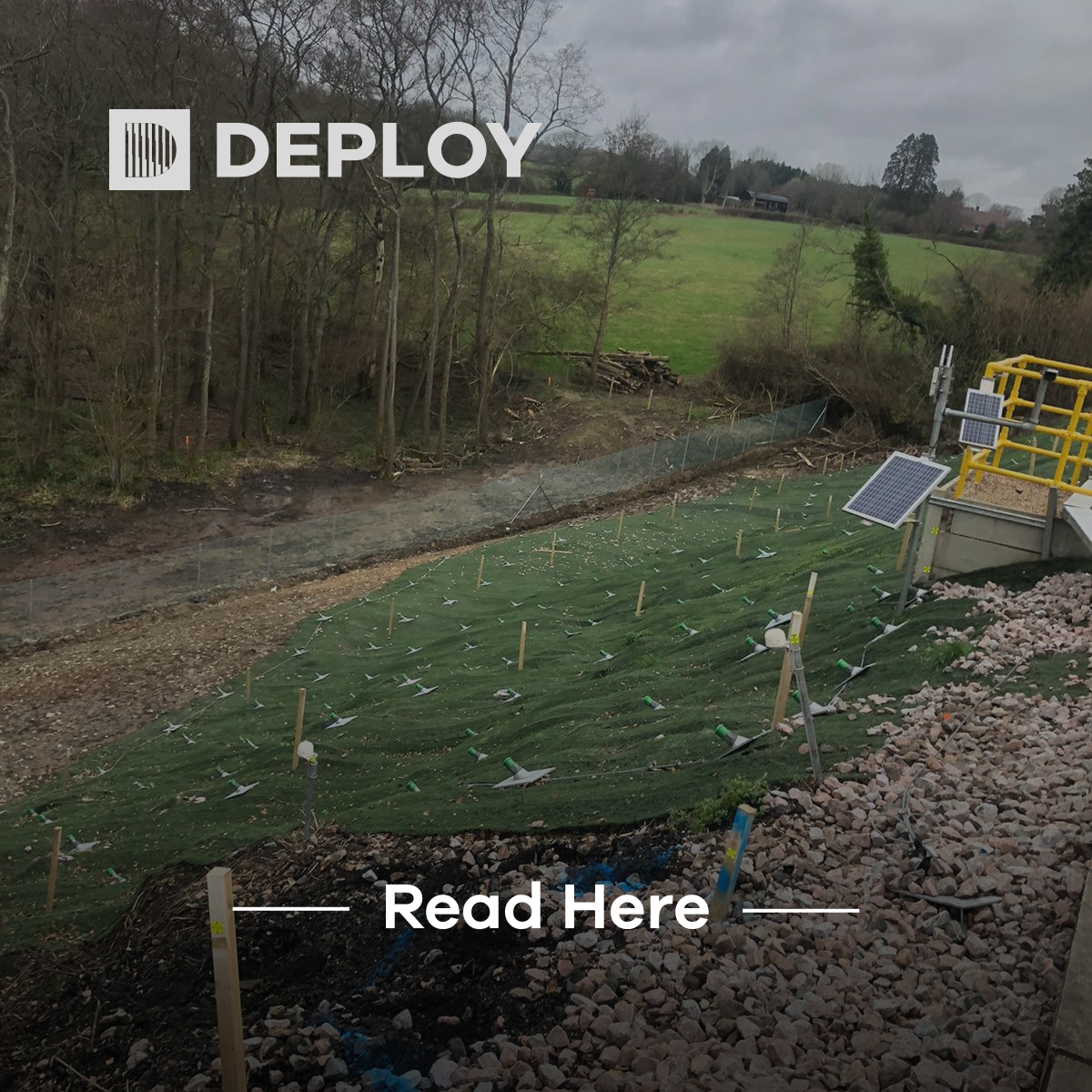 Green landscape with a solar panel, rocky ground, and poles. A logo 
