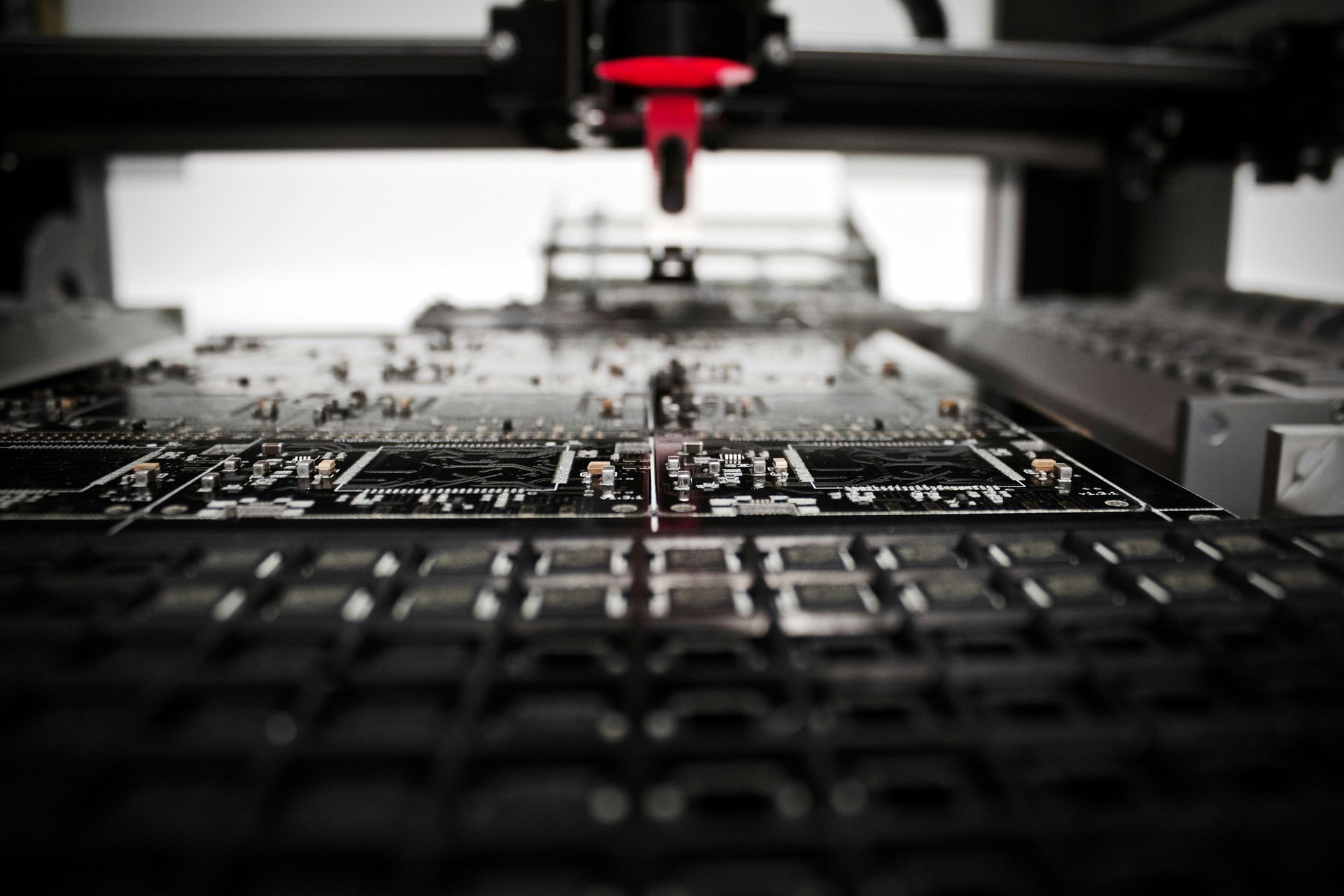 A machine is working on a motherboard in a factory.