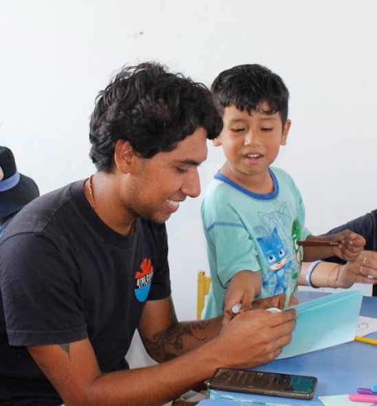 An Otra Cosa volunteer and child working together.