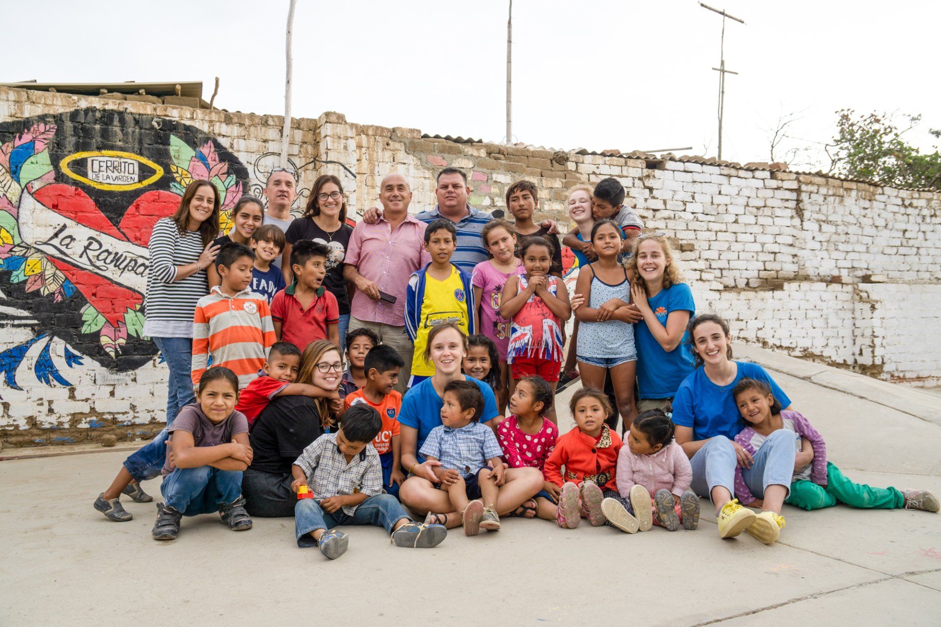 Picture of a group of volunteers and children posing together at our skate ramp.