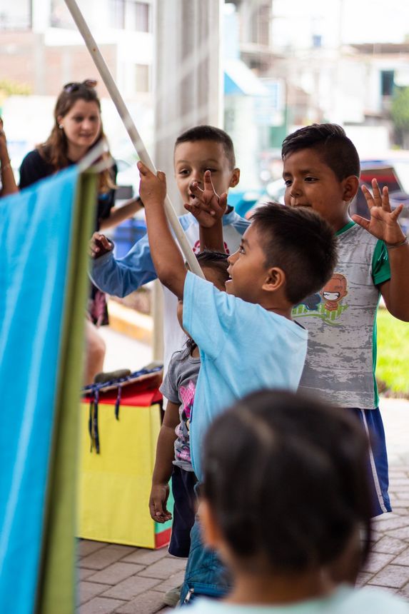 A child playing with an item hanging on a line.