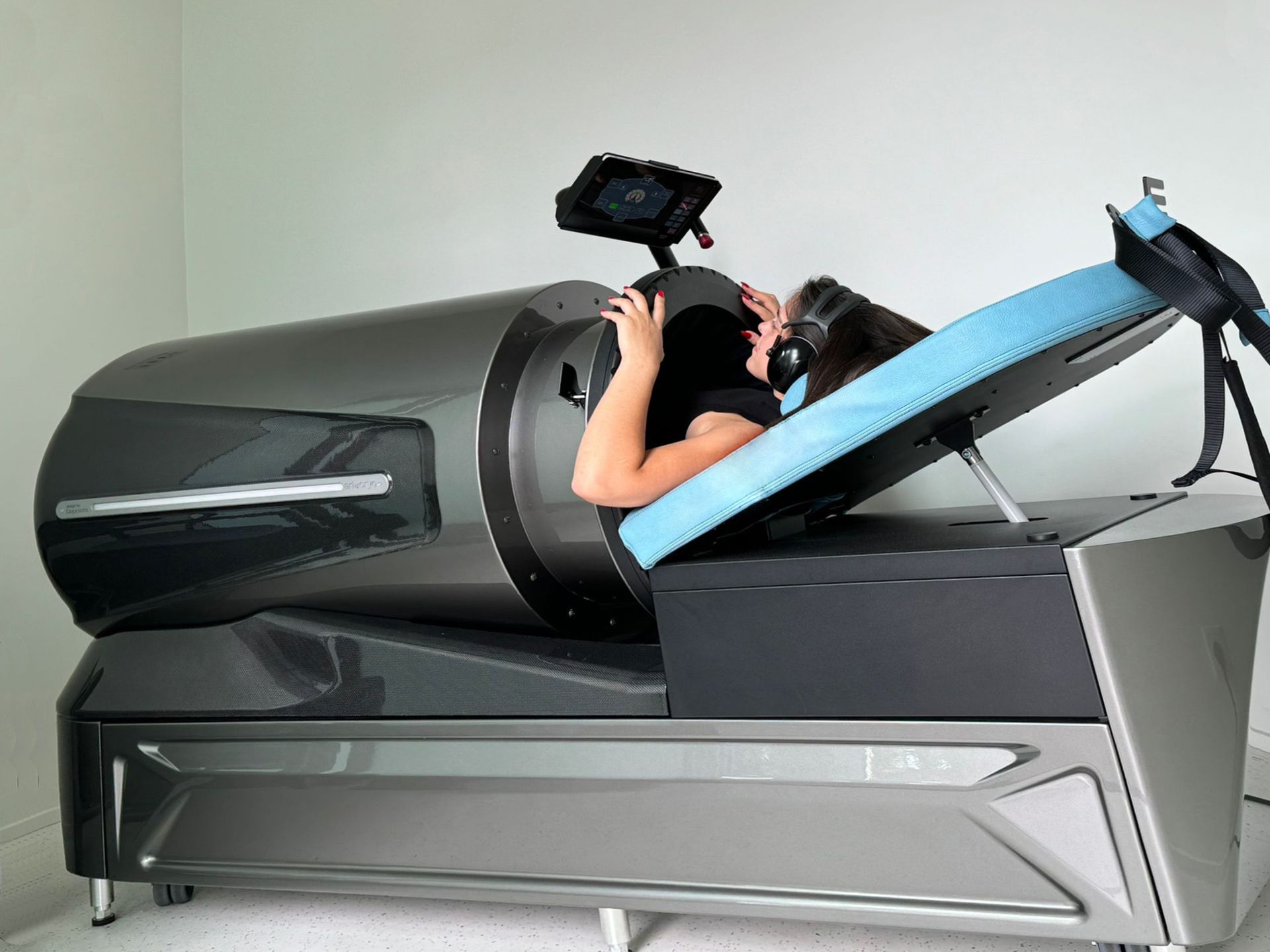 Frau in einer dunkelgrauen und silbernen Wellness-Kapsel, Kopf und Schultern sichtbar bei Flow-System-Therapie.