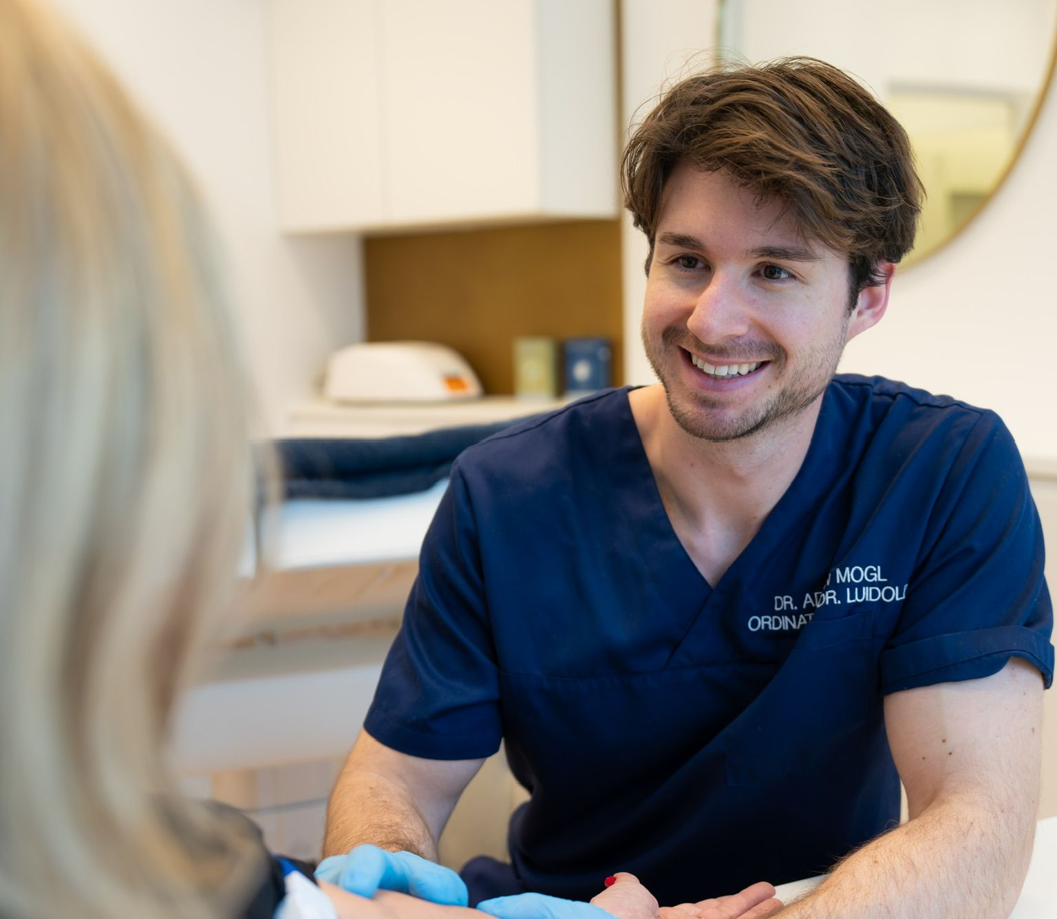 Person interagiert mit einem digitalen Bildschirm, auf dem menschliche Organe und ein weißes Pluszeichen angezeigt werden.