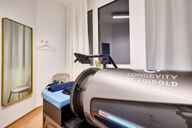 Frau in einer dunkelgrauen und silbernen Wellness-Kapsel, Kopf und Schultern sichtbar bei Flow-System-Therapie.