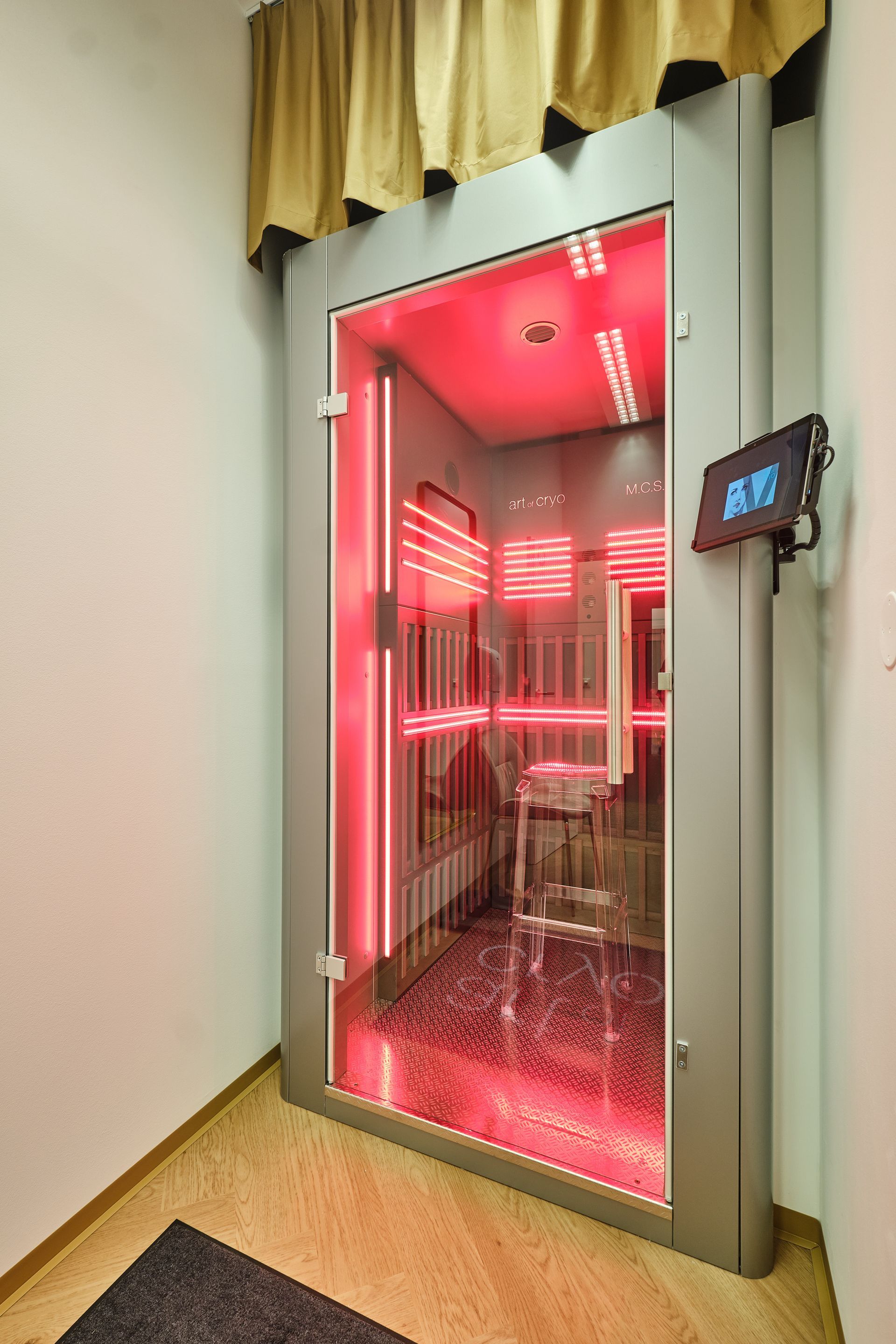 Mann mit Schutzbrille und ohne Hemd in einem rot beleuchteten Raum bei einer MCS-Therapie