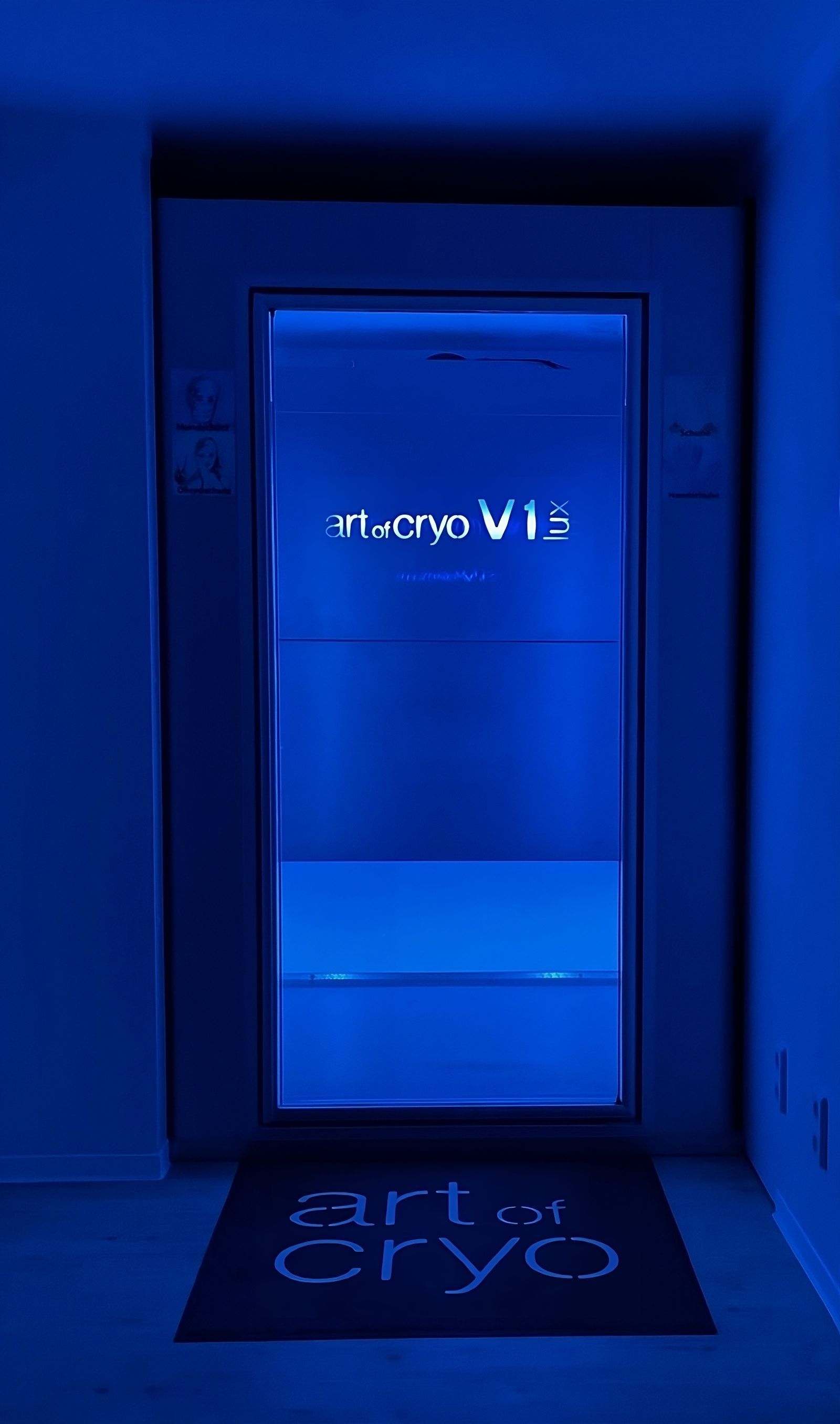 Blau beleuchtete Kryotherapiekammer mit „Art of Cryo“-Matte. 