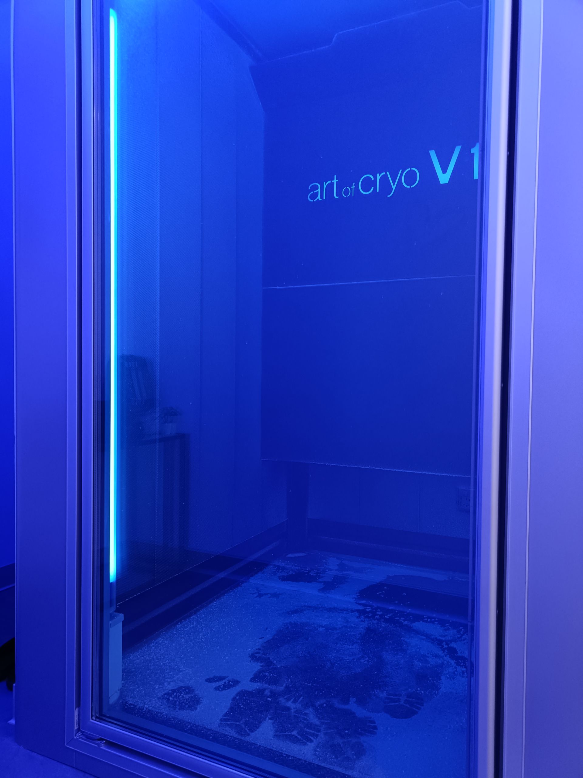 Blau beleuchtete Kryotherapiekammer; eine Person steht darin und wird behandelt.