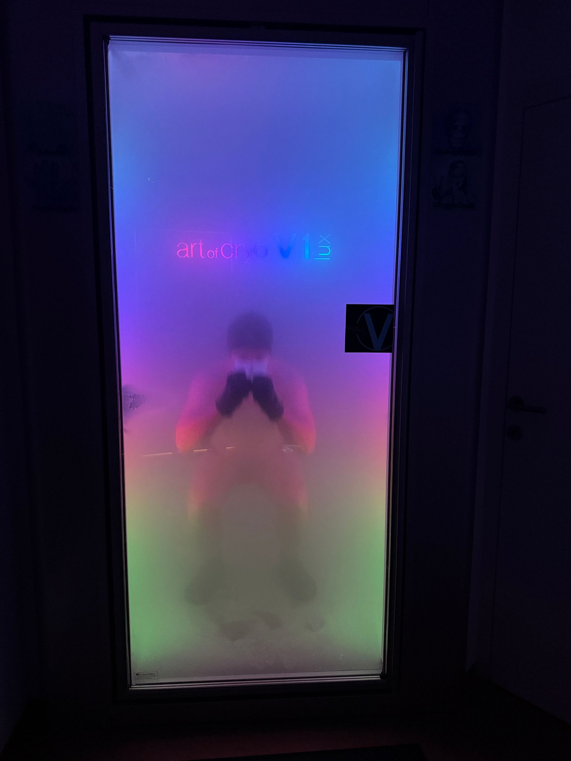 Blau beleuchtete Kryotherapiekammer; eine Person steht darin und wird behandelt.