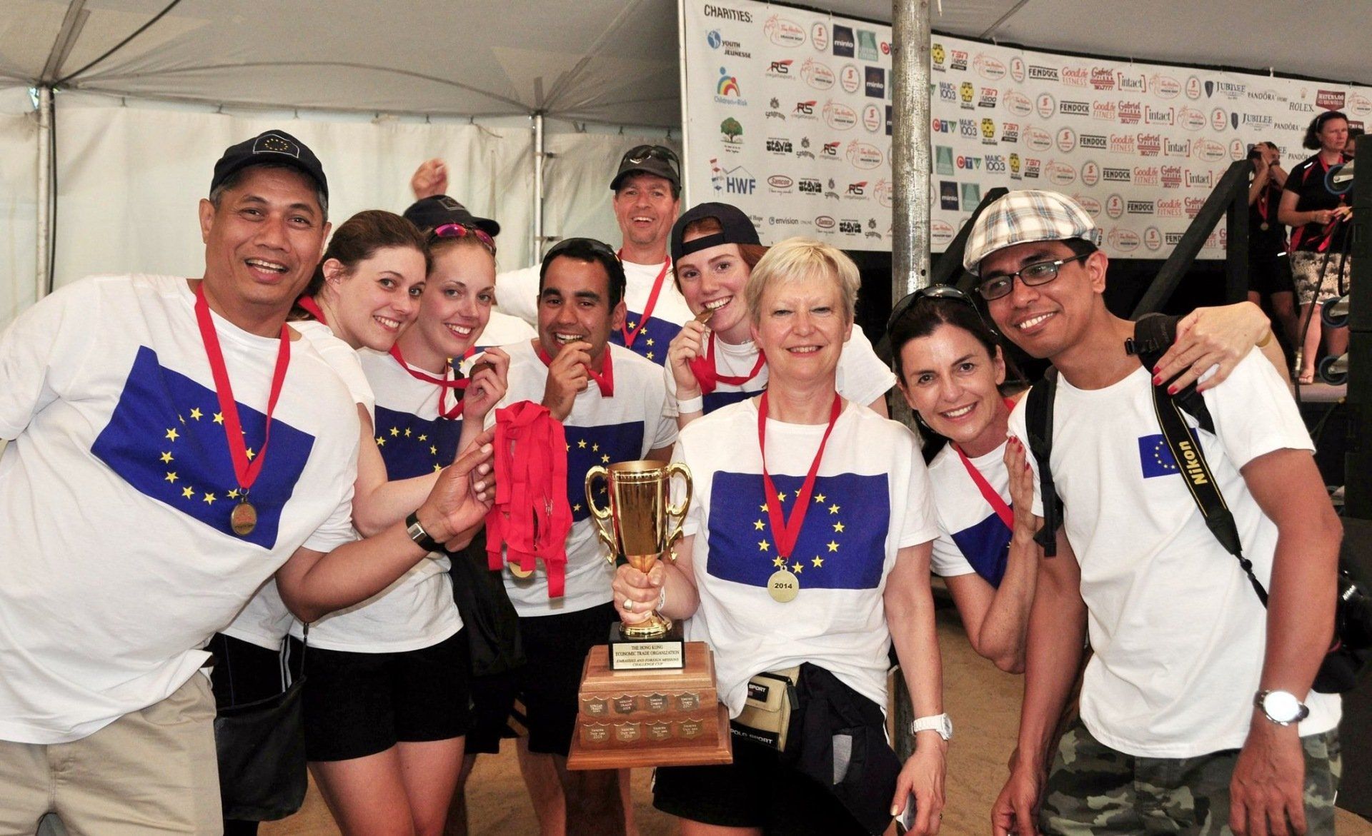 Eine Gruppe von Menschen, die eine Trophäe halten und Medaillen tragen