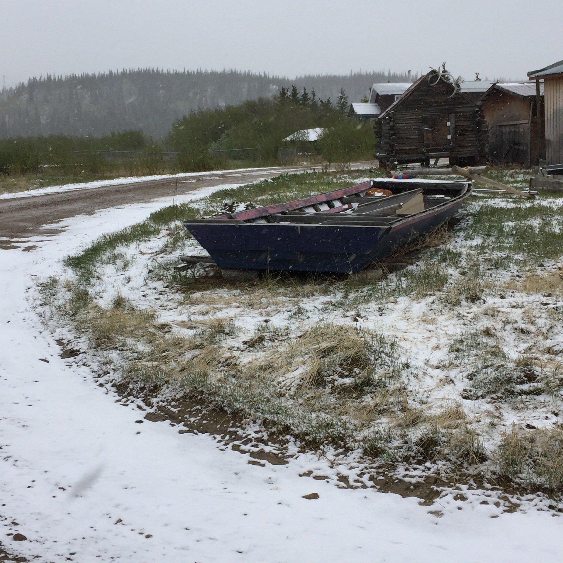 Ein Boot liegt im Schnee neben einer Straße