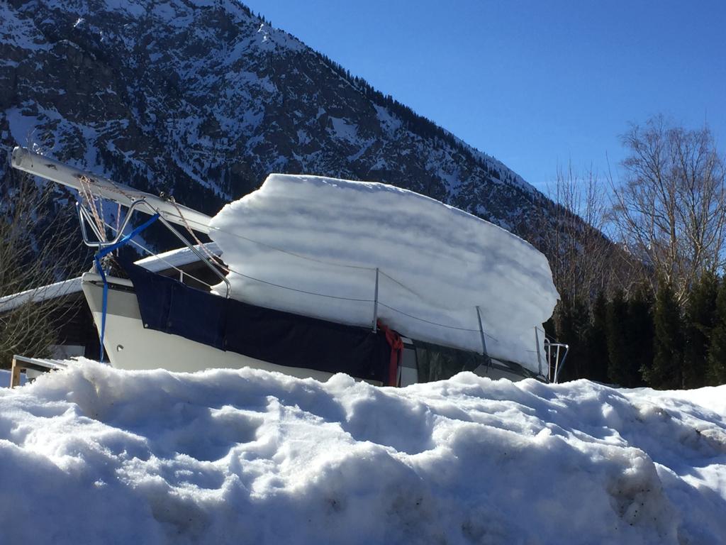Ein schneebedecktes Boot mit einem Berg im Hintergrund